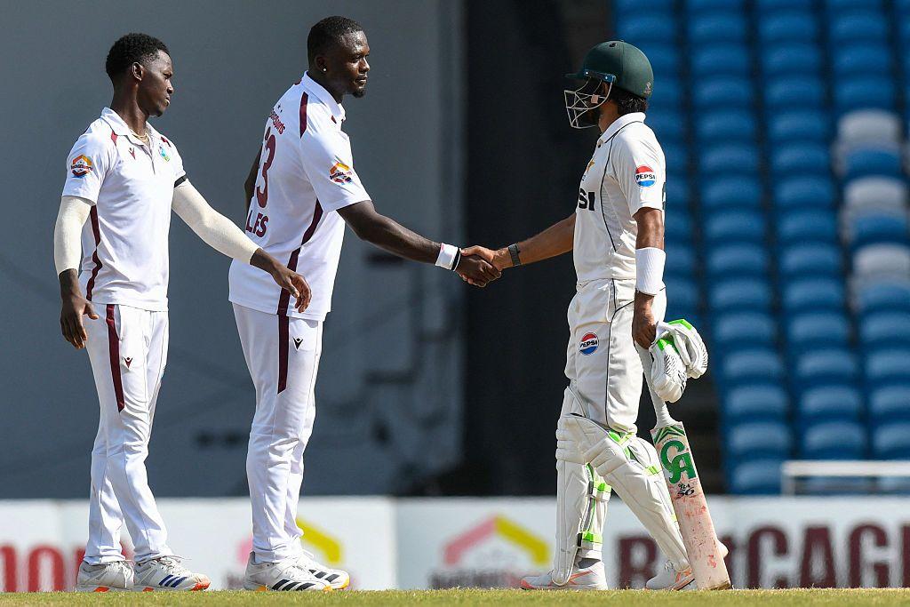 Cricket captain Babar Azam (R) of Pakistan congratulates bowler Jayden Seales (C) and Shamar Joseph of West Indies for their 90-run victory