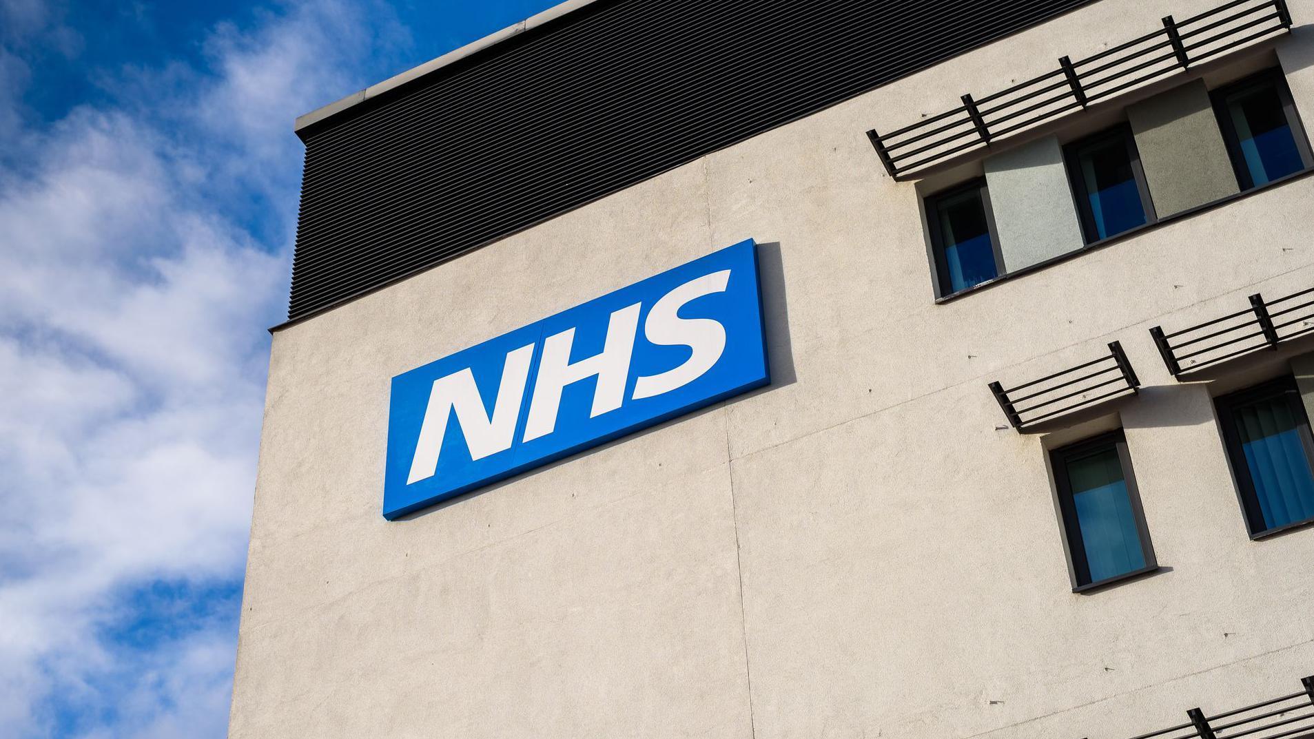 Placa em pr&eacute;dio com o logotipo do NHS