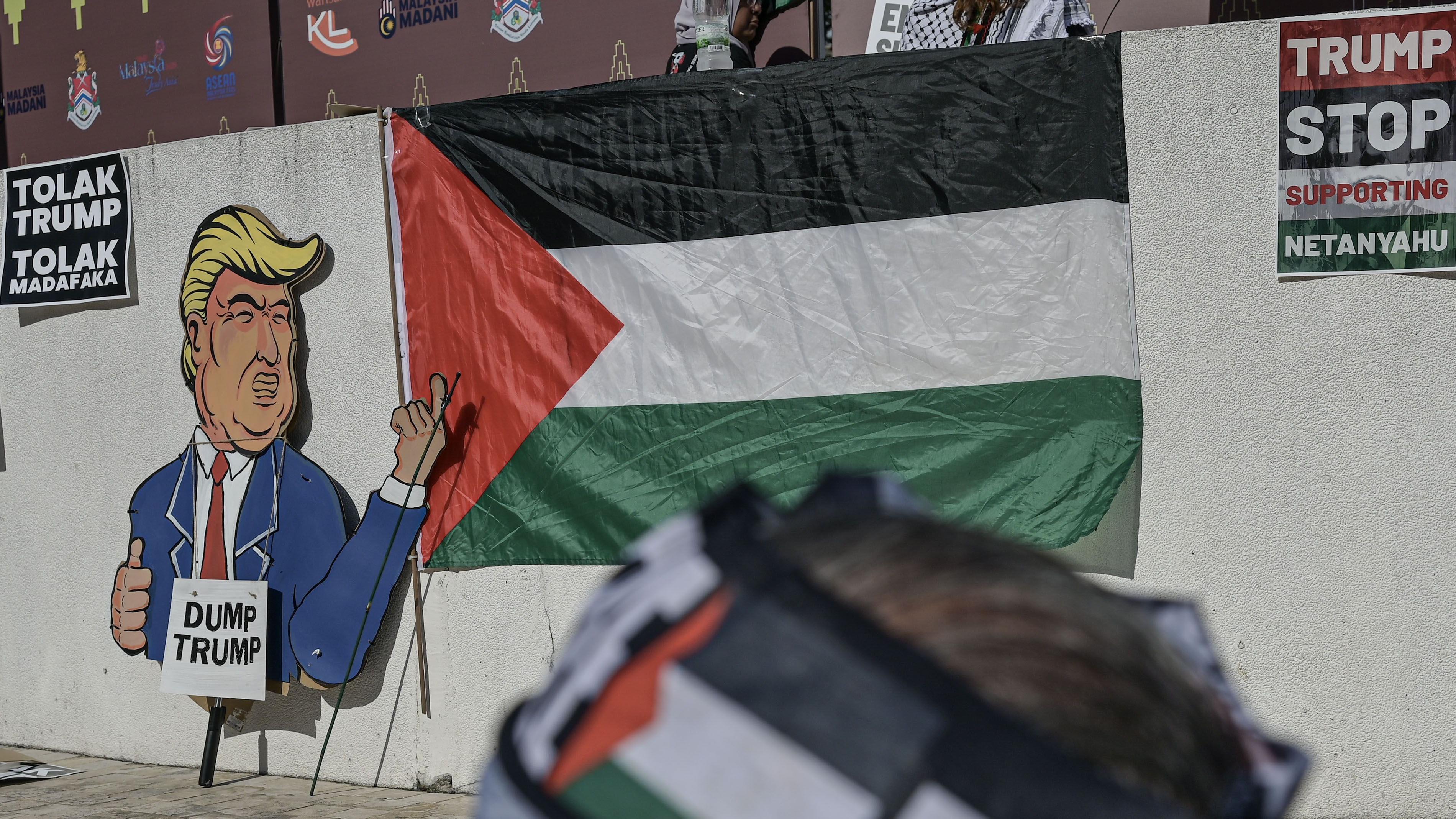 صورة كرتونية لدونالد ترامب بجانب العلم الفلسطيني