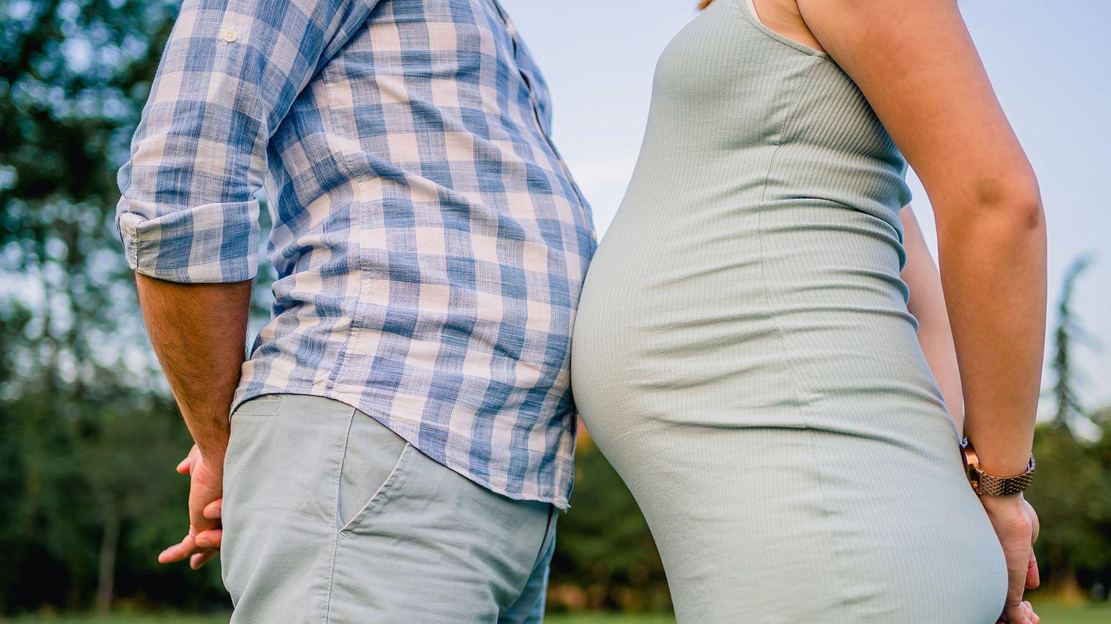 Un hombre choca su barriga contra la de una mujer embarazada.