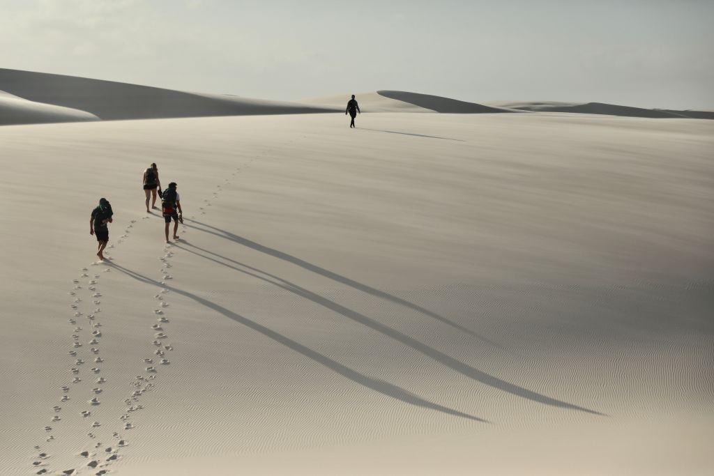 Turistas caminham em dunas 