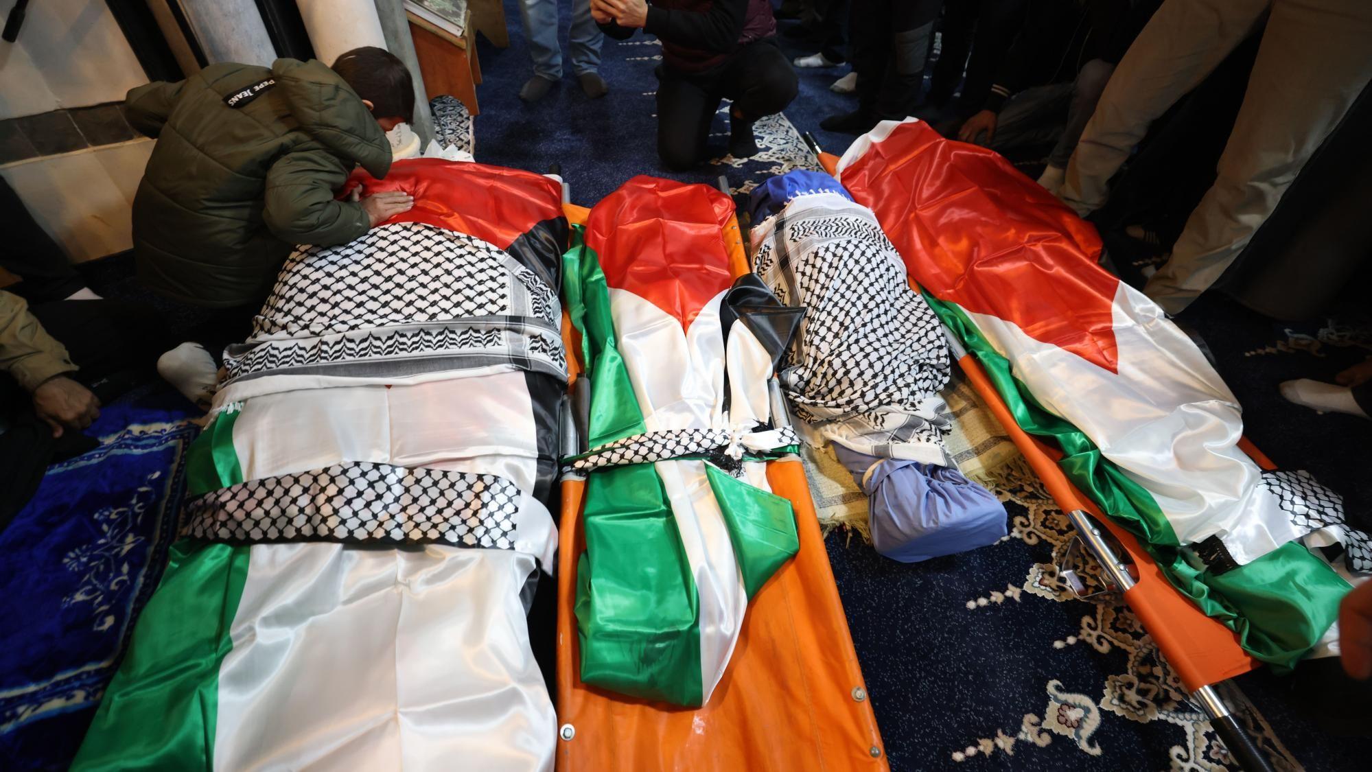 Um dos dois filhos sobreviventes da fam&iacute;lia Bani Odeh lamenta ao lado dos corpos de seus pais e irm&atilde;os durante o funeral em Tammun, na Cisjord&acirc;nia ocupada por Israel (15 de mar&ccedil;o de 2026)
