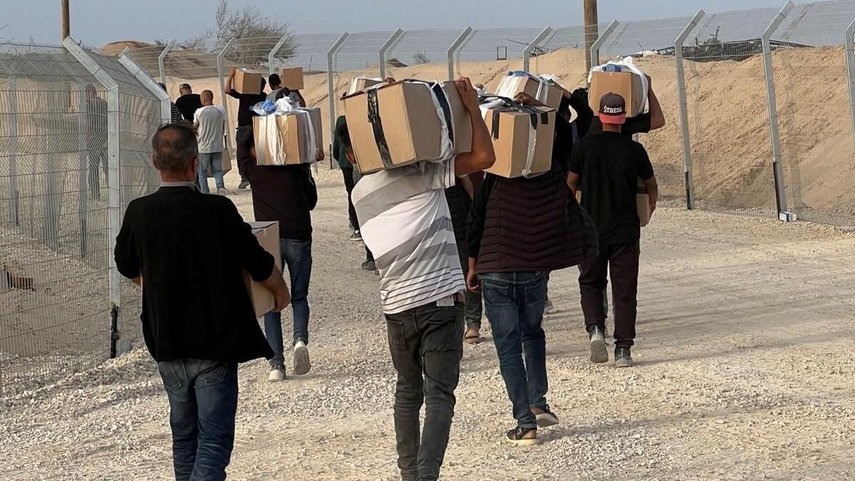 صورة نشرتها مؤسسة غزة الإنسانية، تُظهر رجالاً يحملون صناديق مساعدات في غزة (26 مايو/أيار)