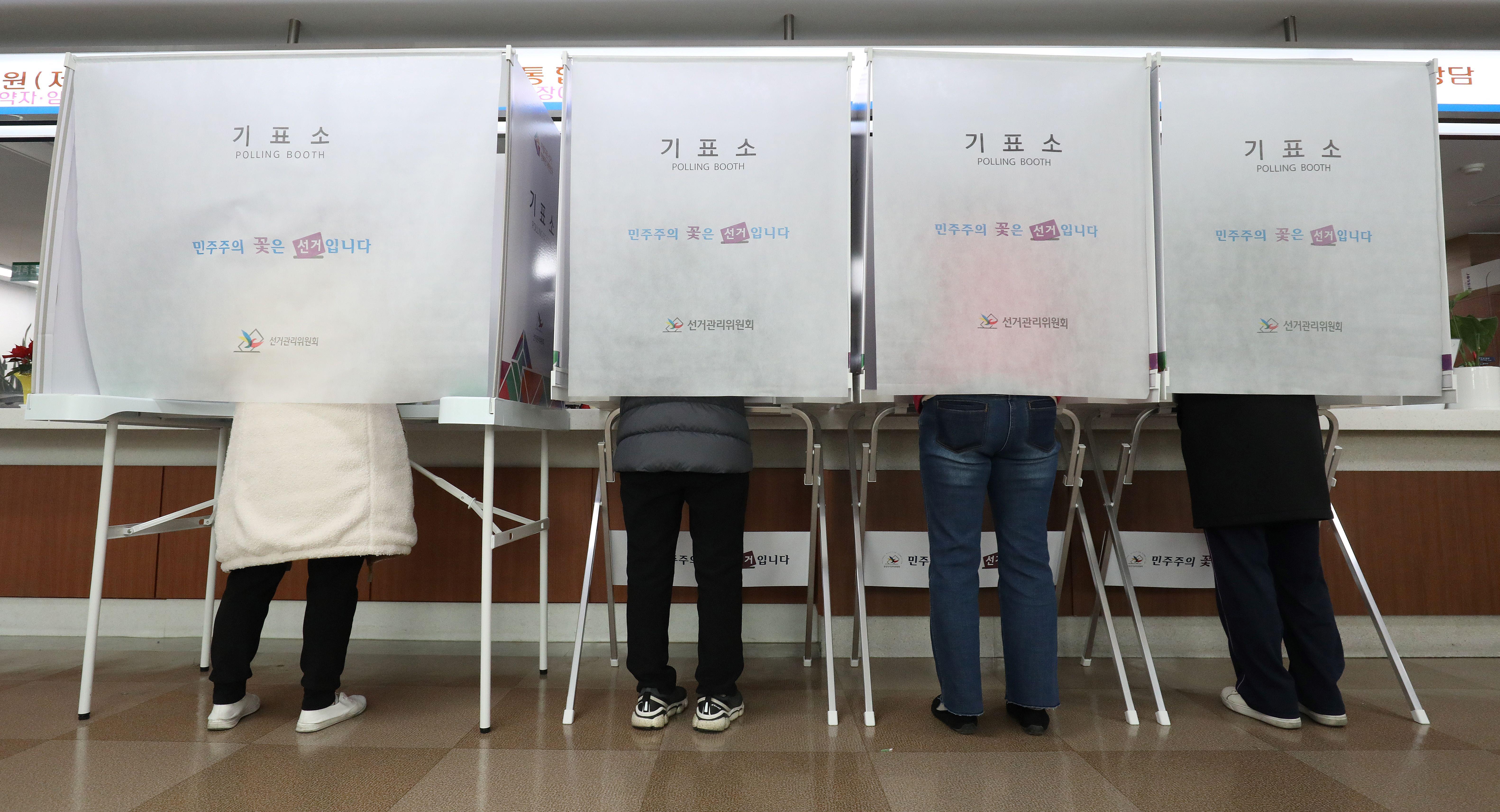 기표소에서 투표하고 있는 시민들