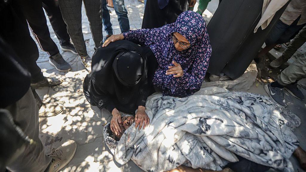 جثث فلسطينيين قتلوا في غارة جوية إسرائيلية على محطة شحن الهواتف المحمولة في حي الشيخ رضوان يتم نقلها إلى مستشفى الشفاء لإجراءات الجنازة في مدينة غزة، غزة