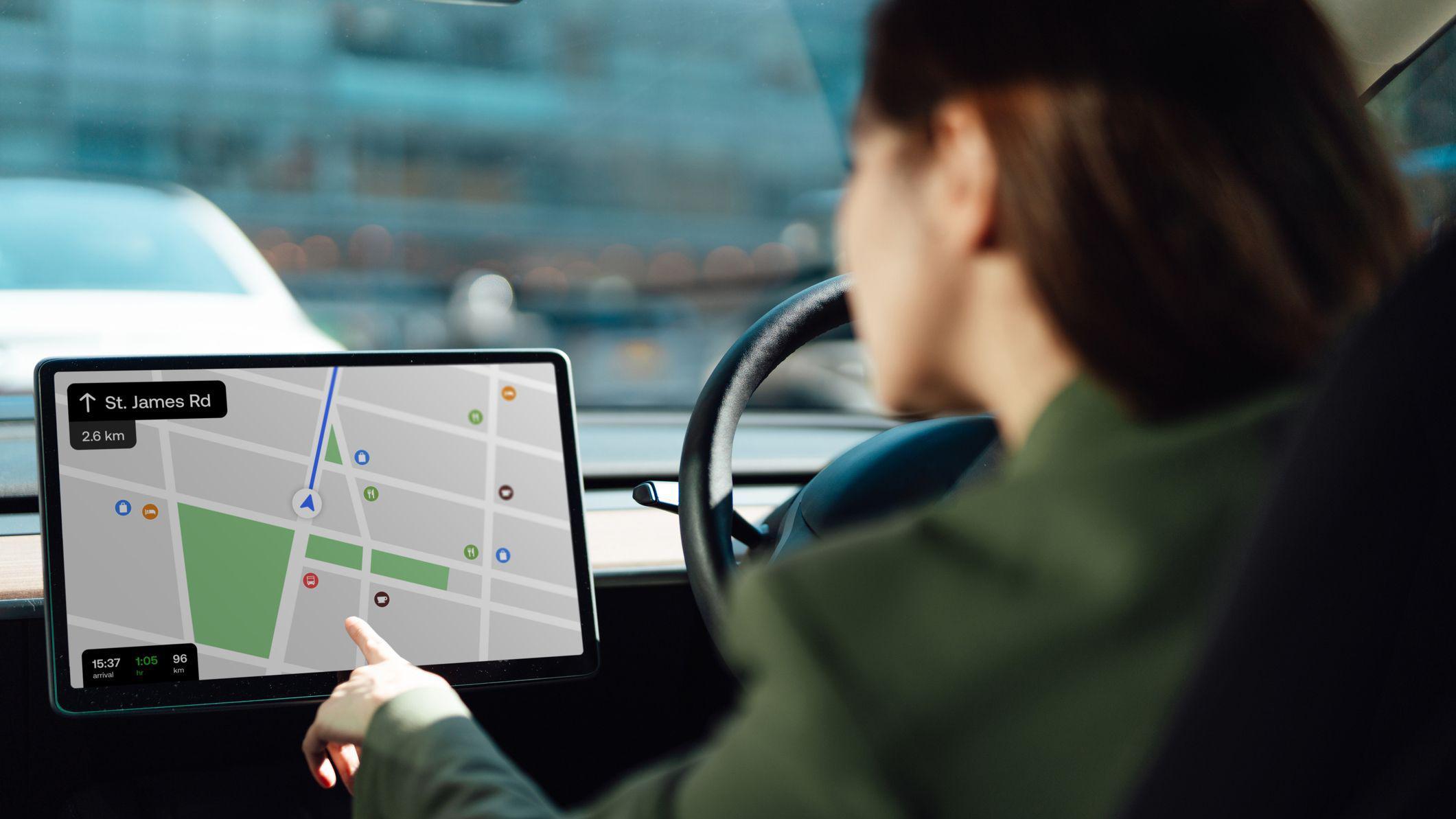 Mujer mirando al GPS en un carro.