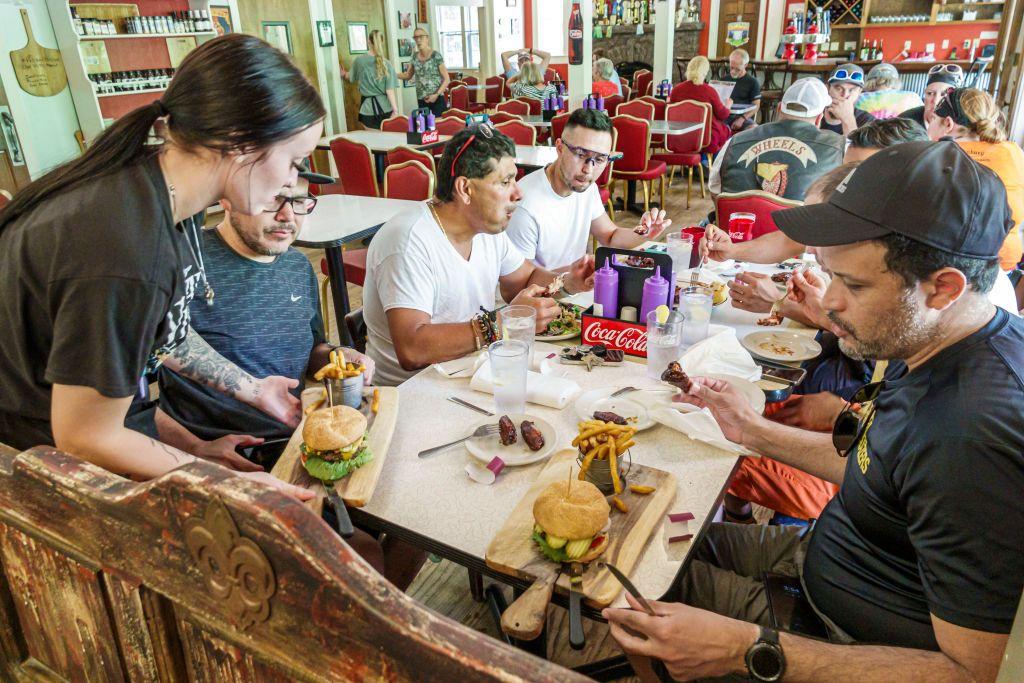 Una camarera sirve hamburguesas a un grupo de personas en un restaurante de Flat Rock, Carolina del Norte.