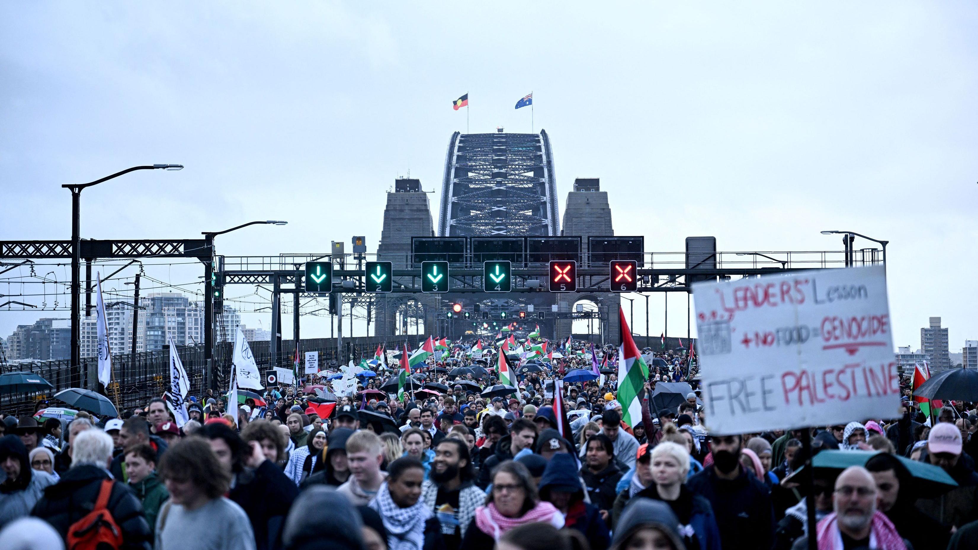 متظاهرون يعبرون جسر ميناء سيدني خلال مظاهرة مؤيدة للفلسطينيين ضد تصرفات إسرائيل ونقص الغذاء المستمر في قطاع غزة، في سيدني في 3 أغسطس/آب 2025.