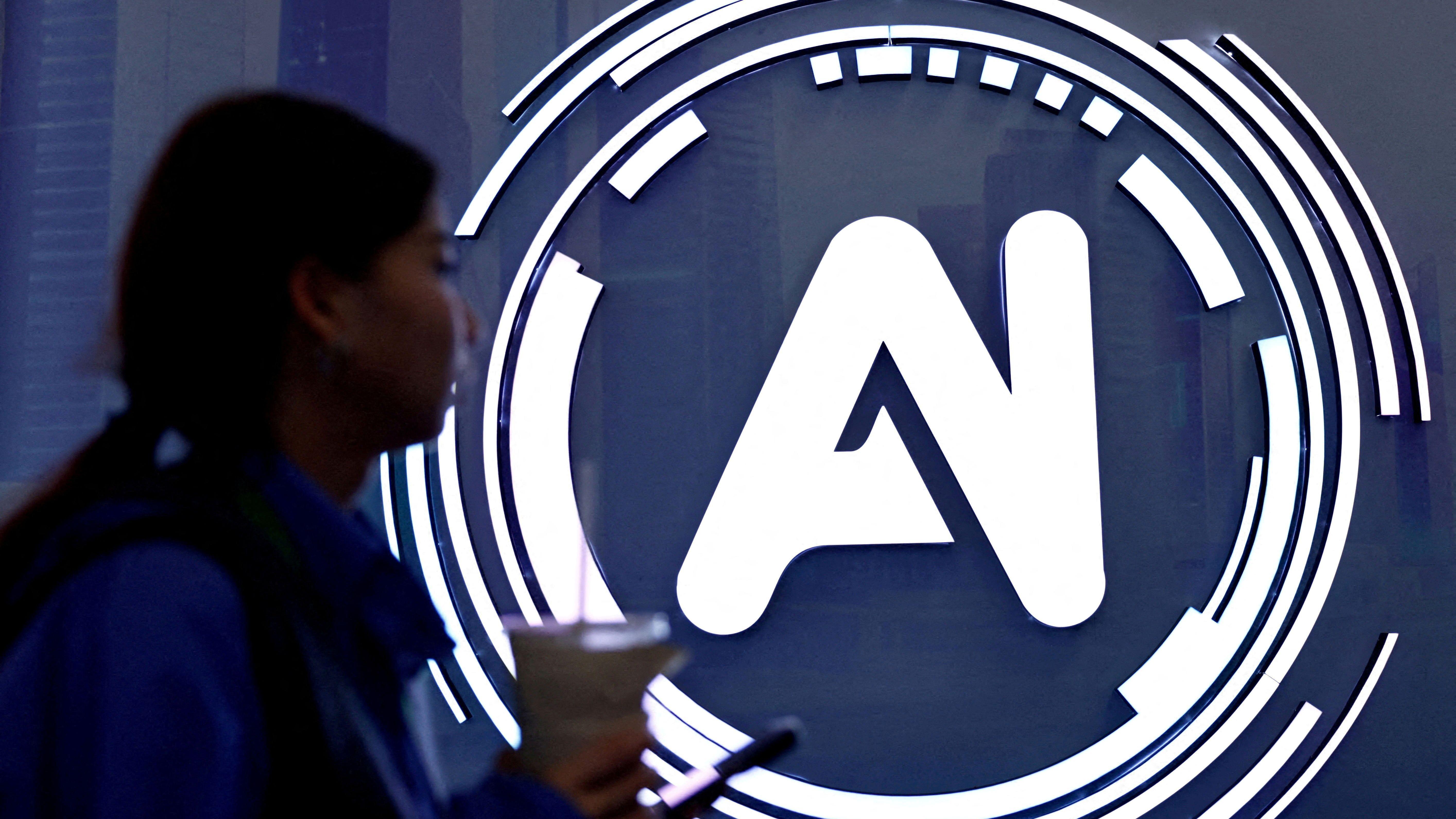 امرأة تمر أمام لافتة كُتب عليها "الذكاء الاصطناعي" في مؤتمر الإنترنت العالمي في الصين