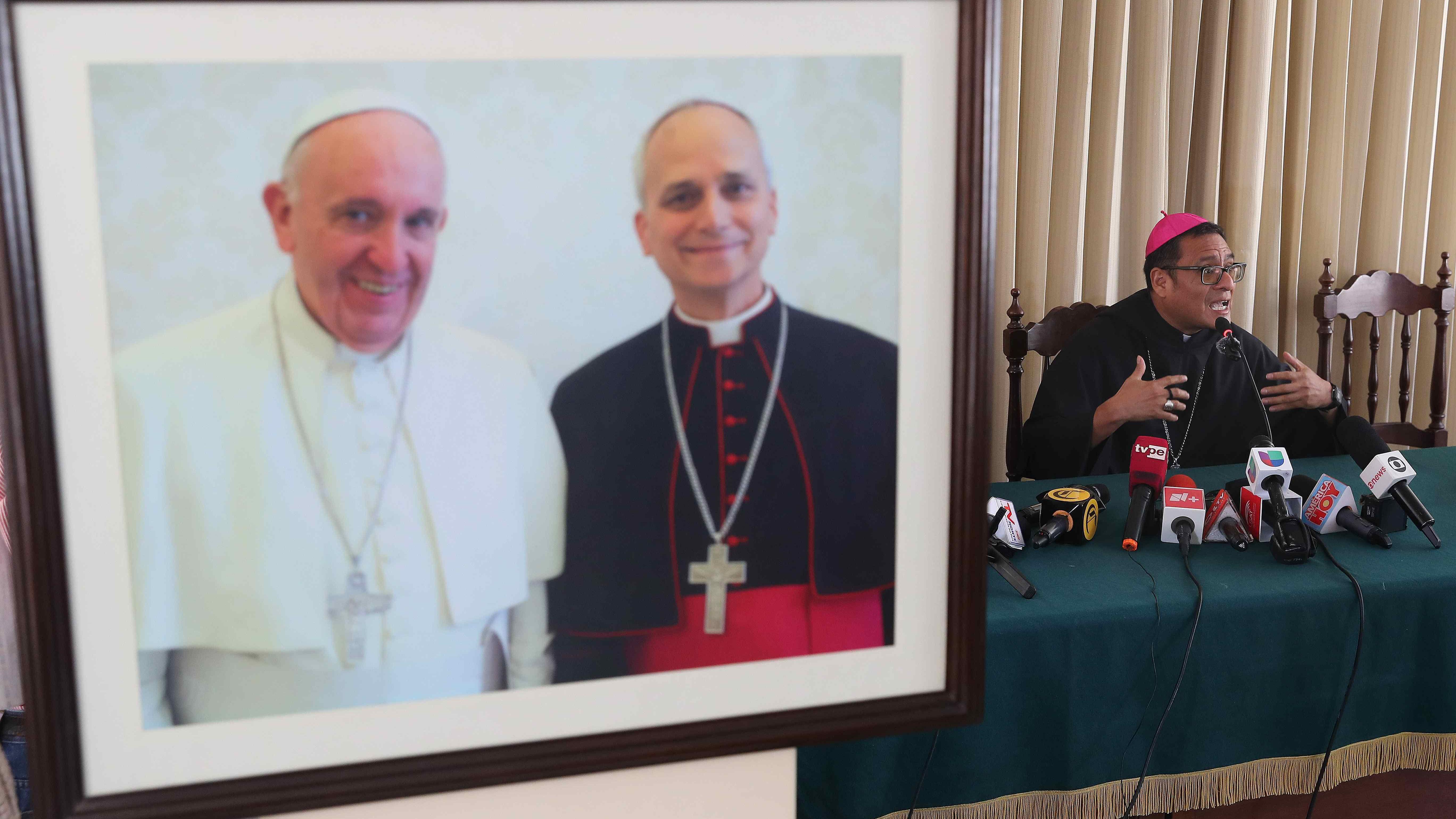 El obispo de Chiclayo, monseñor Edinson Farfán Córdova, habla durante una conferencia de prensa en Chiclayo, Perú, el 9 de mayo de 2025, junto a una fotografía del entonces obispo Robert Francis Prevost (R) junto al papa Francisco en el obispado de Chiclayo.