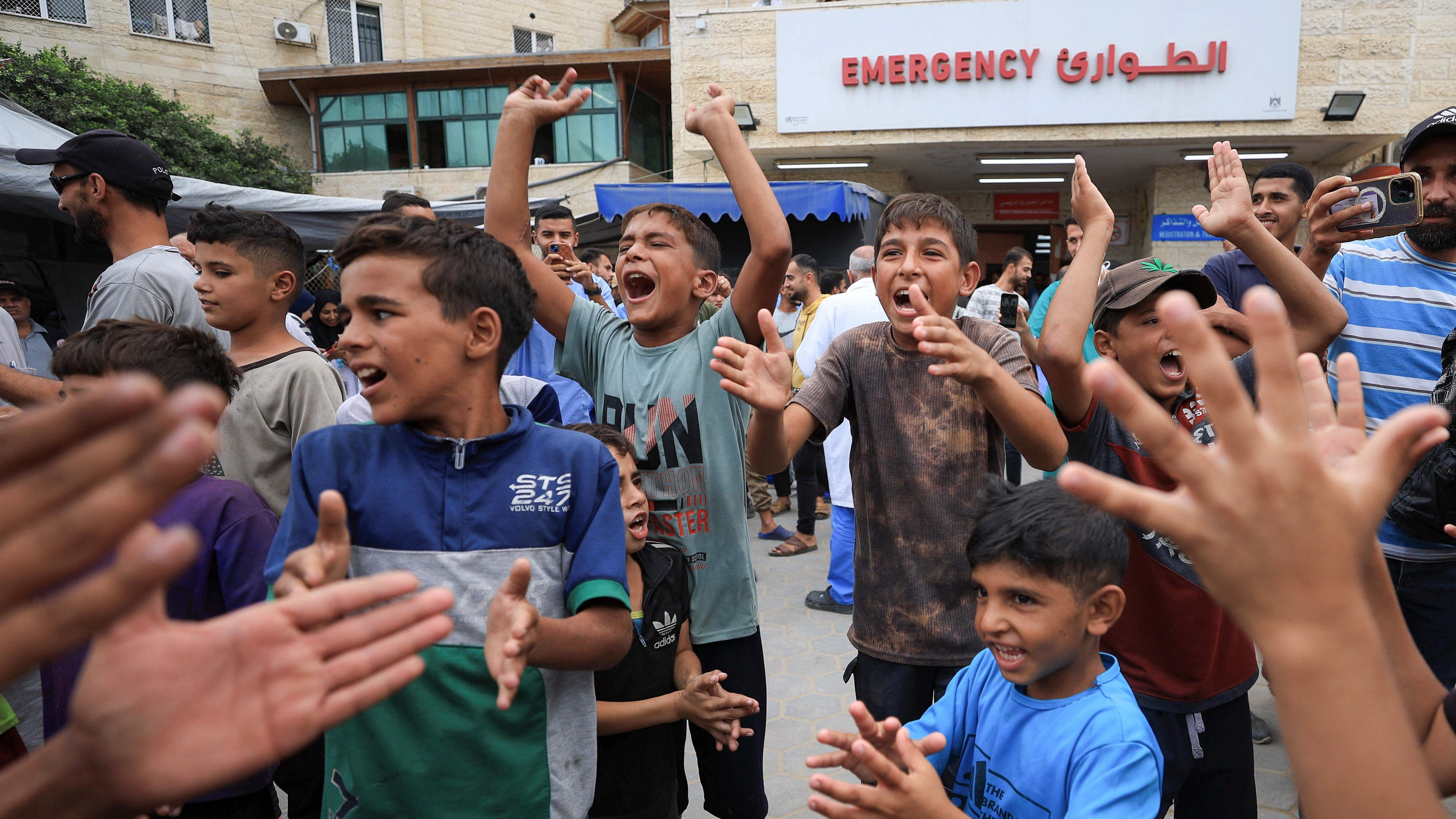 Palestinska deca slave pošto su Izrael i Hamas postigli dogovor o prvoj fazi prekida vatre. Neka tapšu rukama a nekima su ruke podignute gore i uzvikuju