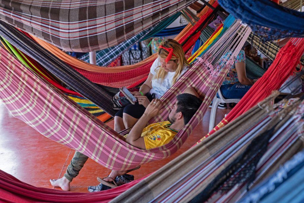Turistas deitados em rede em barco navegando pela Amaz&ocirc;nia