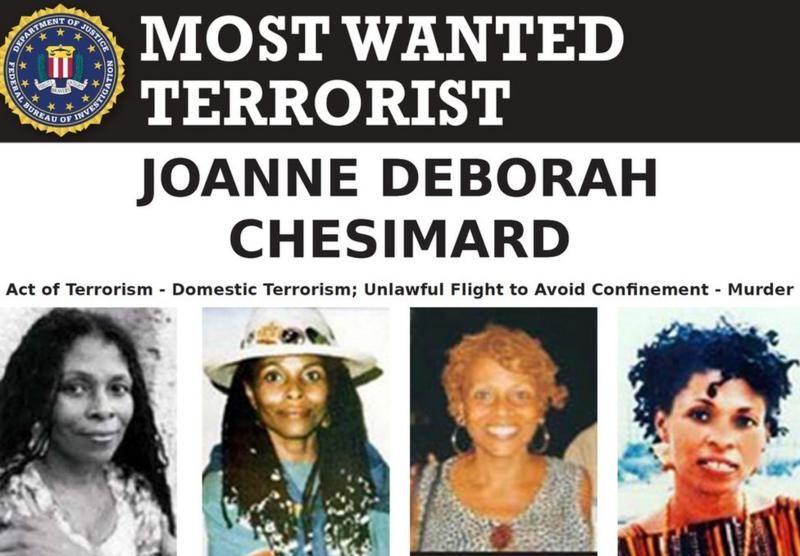 Cartel del FBI con cuatro fotografías de JoAnne Chesimard bajo un texto que la identifica como "terrorista más buscada". 