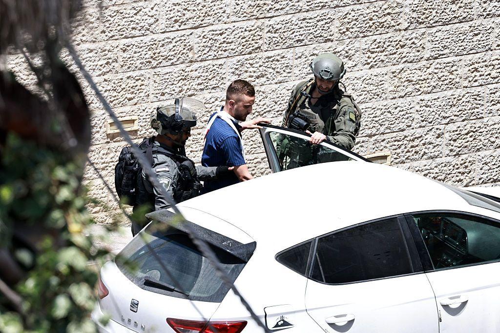 جنود الجيش الإسرائيلي يعتقلون رجلاً أثناء مداهمة محل صرافة في رام الله بالضفة الغربية المحتلة في 27 مايو 2025.