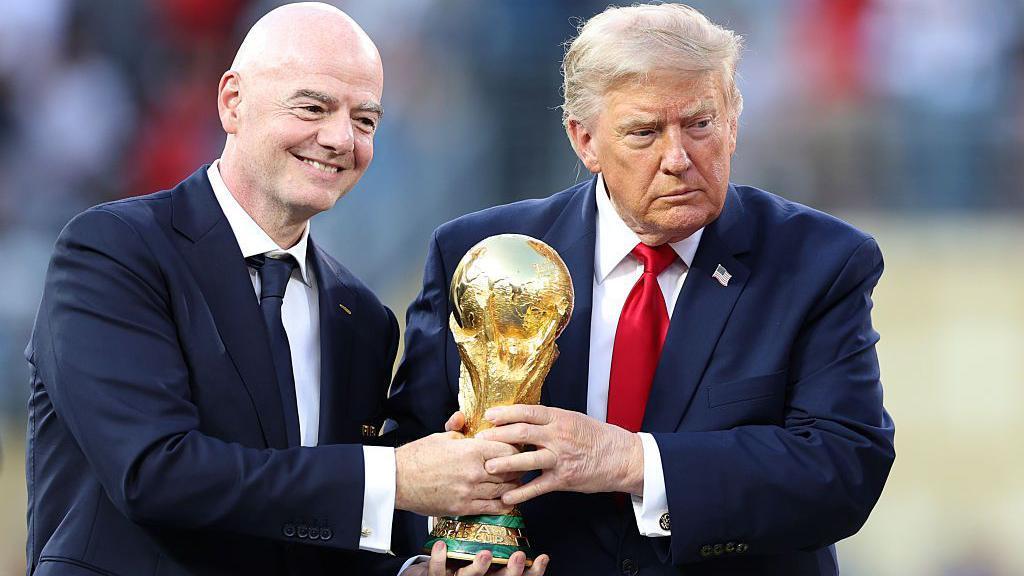 الرئيس الأمريكي دونالد ترامب (يمين) يمسك كأس العالم مع رئيس الفيفا جياني إنفانتينو