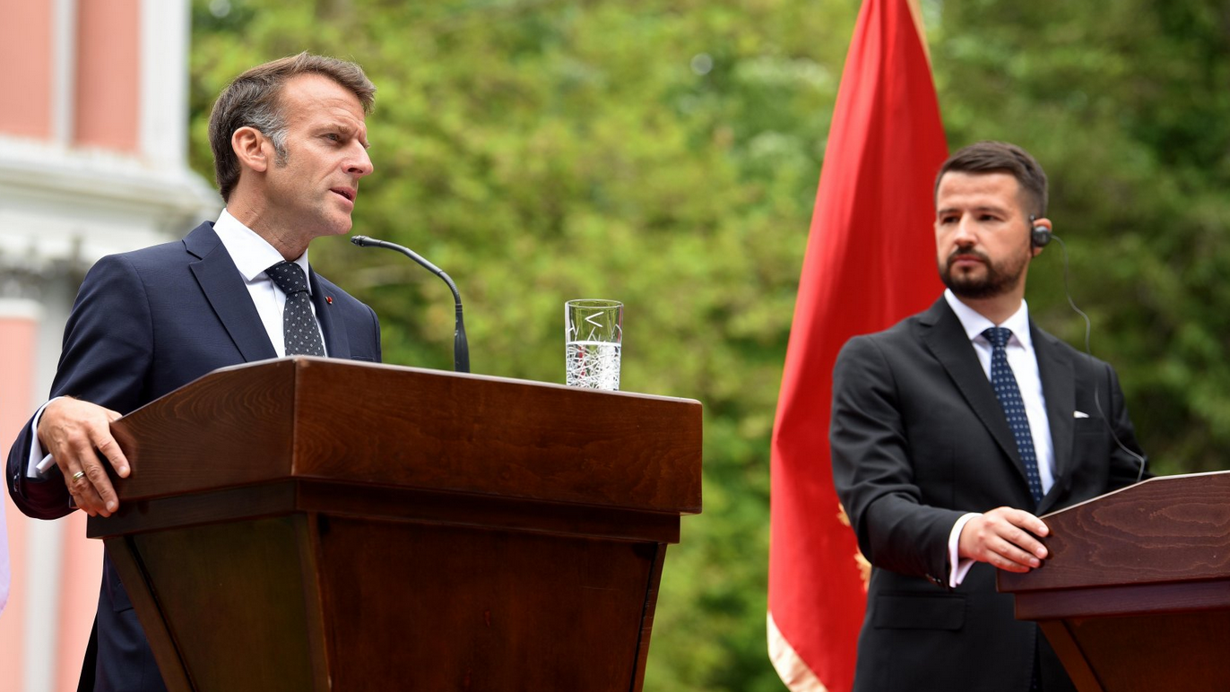 Dva muškarca govore pred govornicama, u odelima, iza jednog je crnogorska zastava
