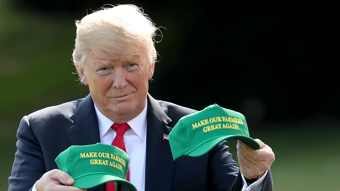 特朗普手持兩頂印有「讓我們的農民再次偉大」（Make Our Farmers Great Again）字樣的綠色帽子