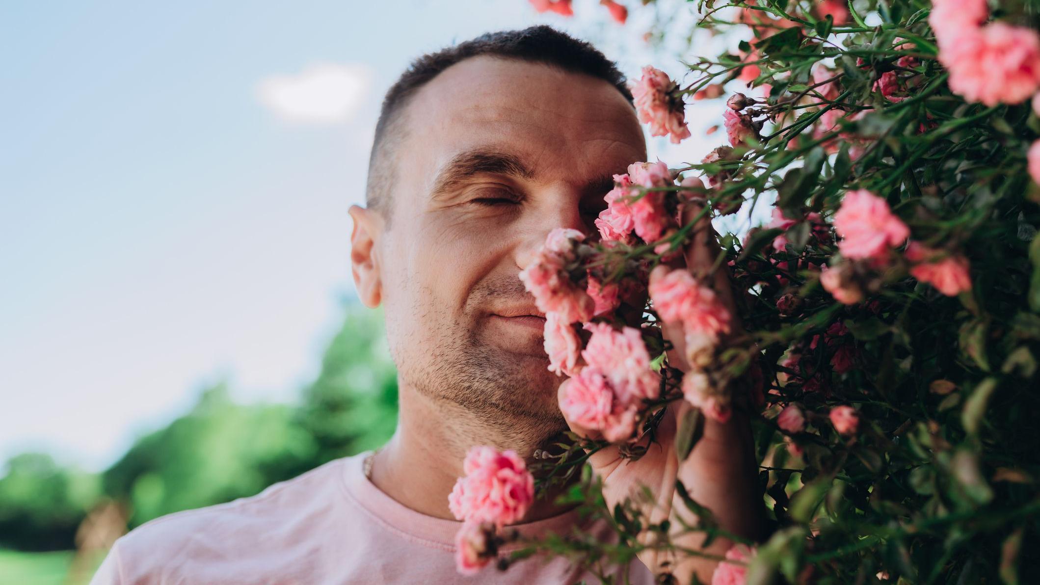 Hombre oliendo unas flores