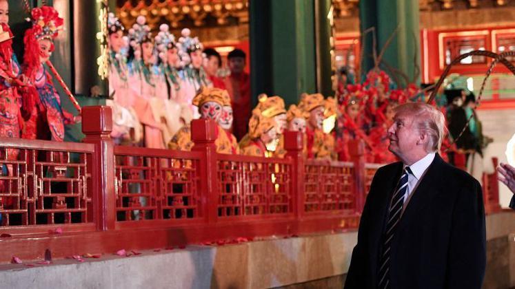 US President Donald Trump (C) looks at opera performers beside China's President Xi Jinping (R) at the Forbidden City in Beijing on November 8, 2017. US President Donald Trump toured the Forbidden City with Chinese leader Xi Jinping on November 8 as he began the crucial leg of an Asian tour intended to build a global front against North Korea's nuclear threats.