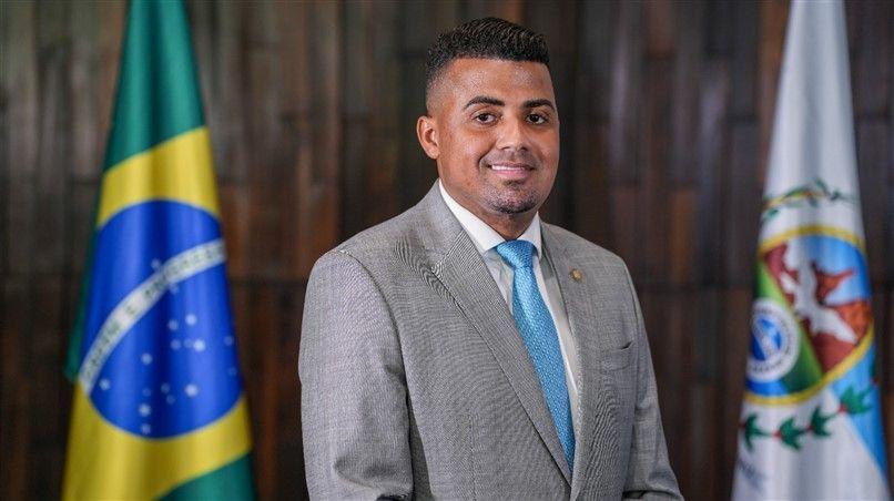 TH Joias em retrato formal na Alerj, com bandeiras do Brasil e do RJ atr&aacute;s