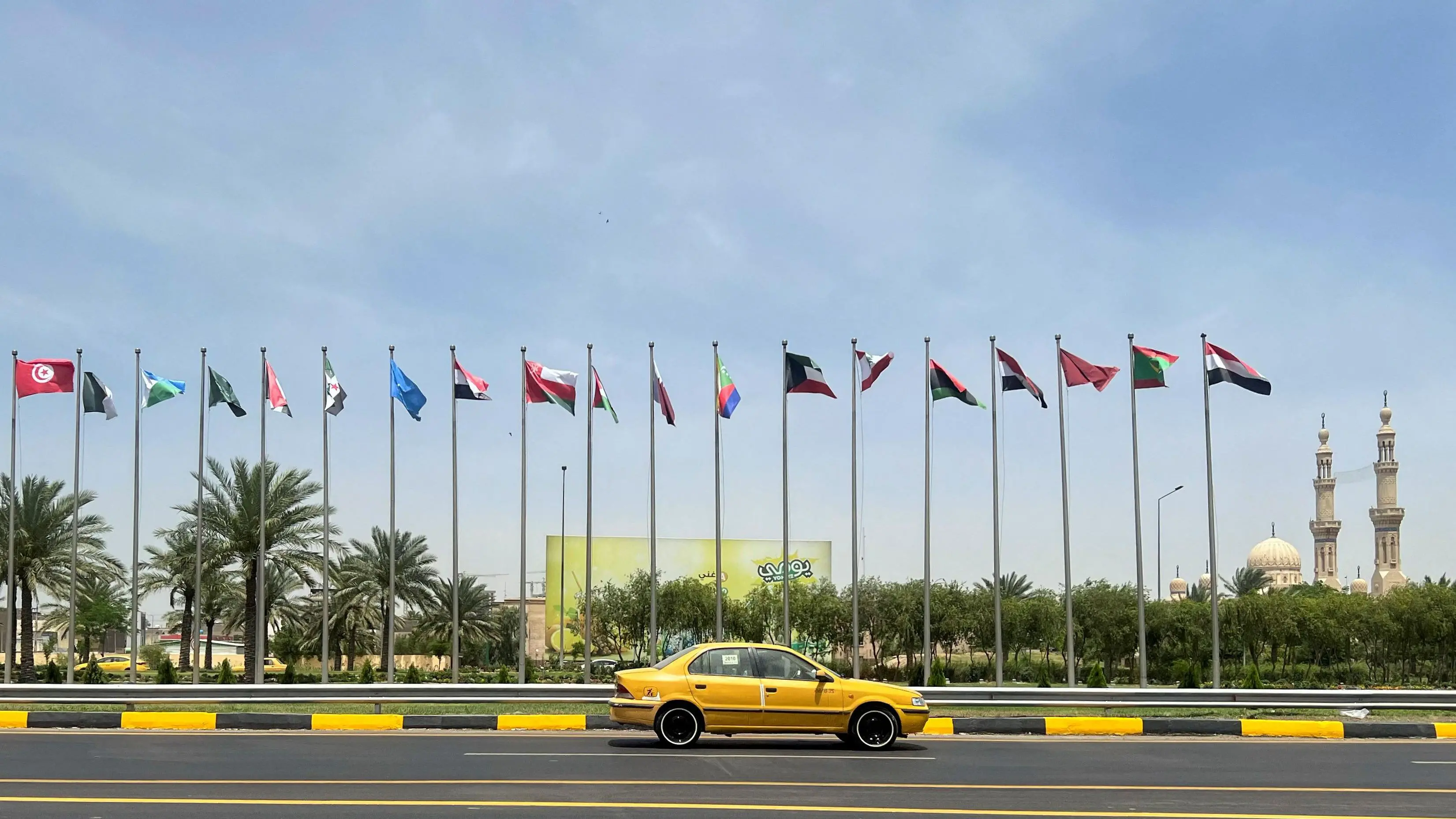 أعلام الدول الأعضاء في جامعة الدول العربية المعروضة على طول الشارع قبل انعقاد القمة العربية الرابعة والثلاثين في بغداد، العراق، 15 مايو/أيار 2025
