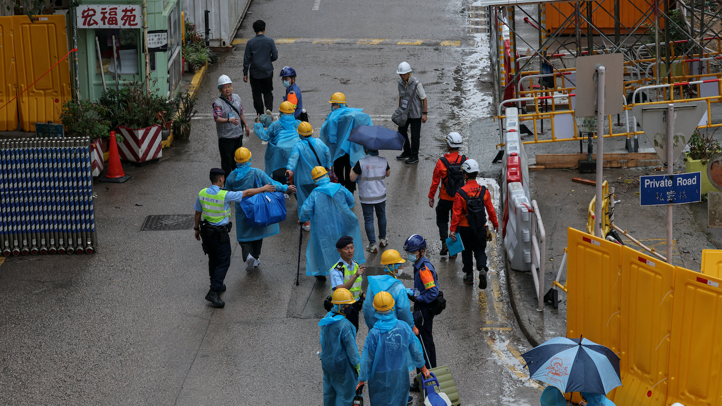 宏福苑居民身穿藍色保護衣、戴上黃色頭盔，在警務人員及民安隊陪同下進入大廈。