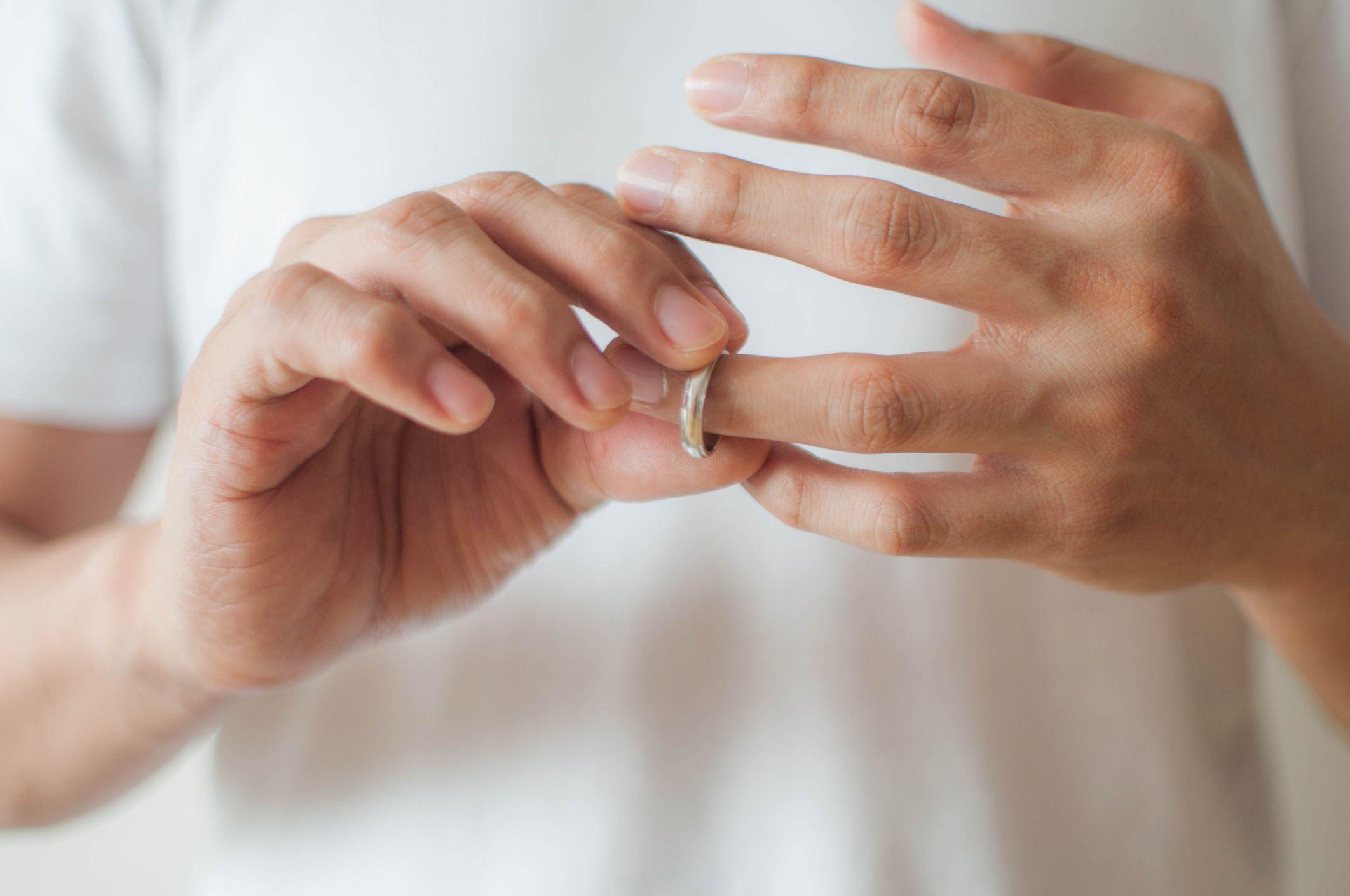 Un hombre se quita el anillo de casado de su dedo