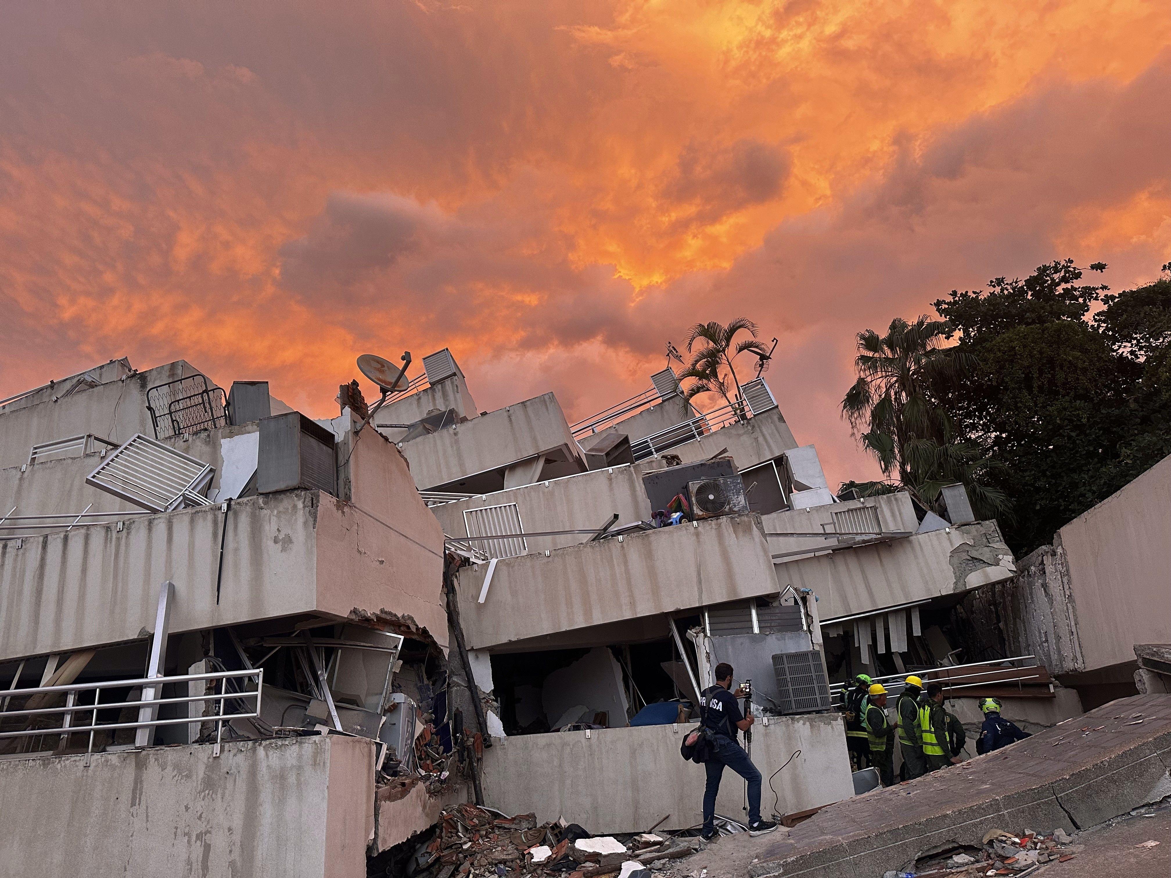 Residencias Vistamar con un atardecer intenso, frente a playa El Yate, Caraballeda. Se ven rescatistas trabajando.