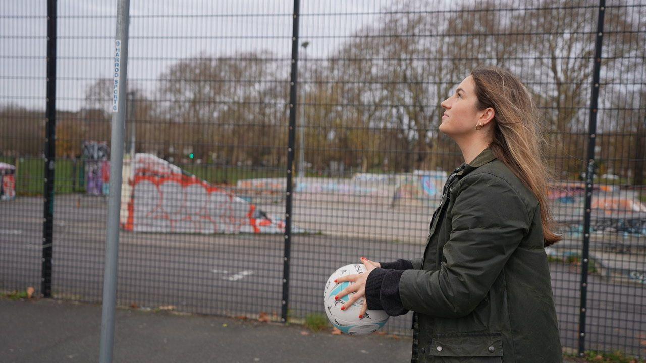 Kejtlin drži u ruci loptu