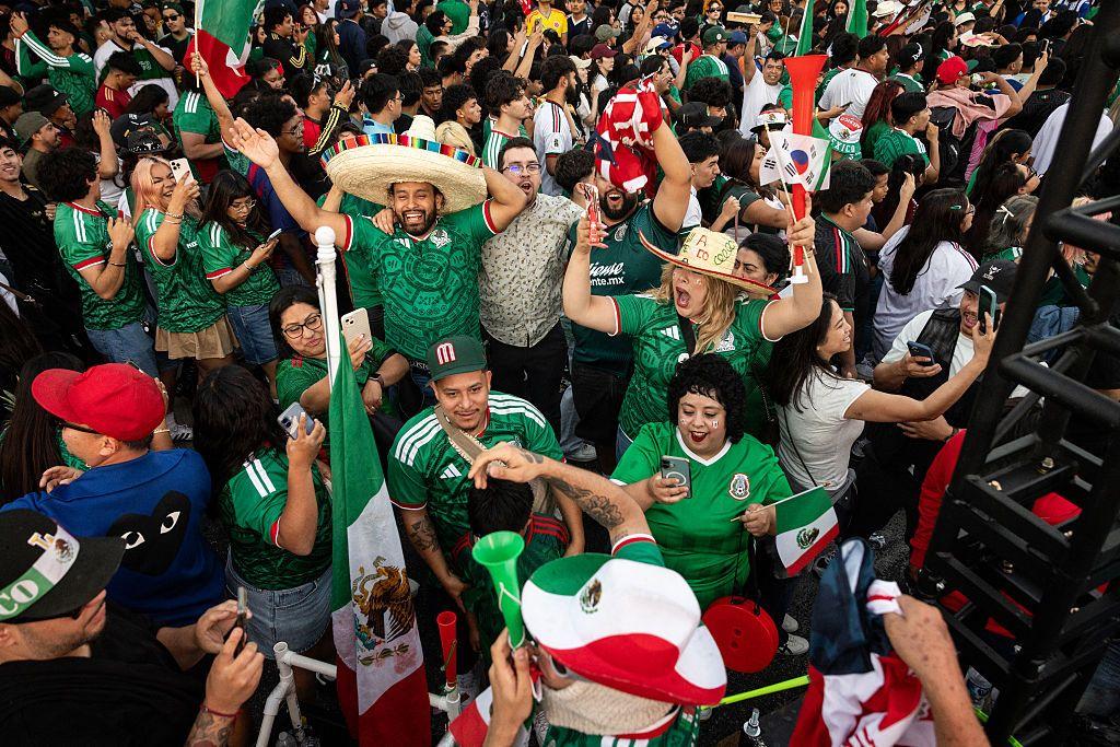 Los aficionados mexicanos celebran la victoria de su equipo en el partido del Mundial de 2026 entre Corea del Sur y México, van vestidos con la camiseta de la selección.