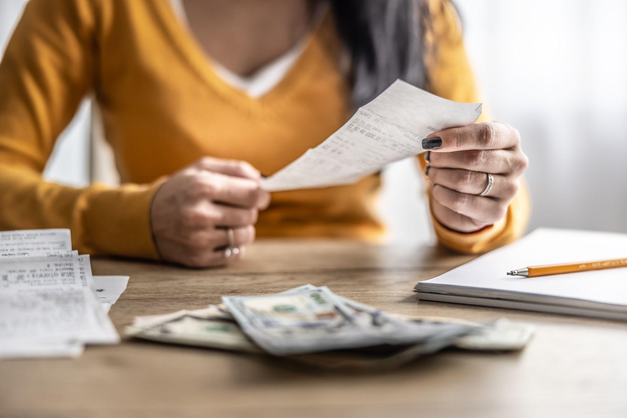 Mujer con dinero y cuentas en una mesa