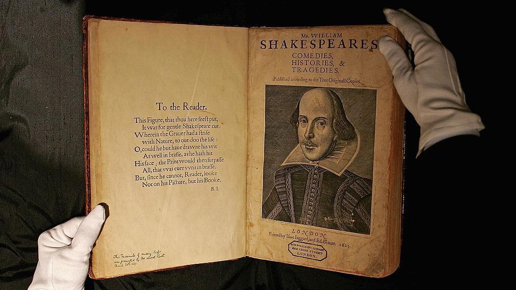 A primeira edi&ccedil;&atilde;o original de uma obra de Shakespeare, aberta entre as m&atilde;os cobertas por luvas de um funcion&aacute;rio de uma casa de leil&otilde;es