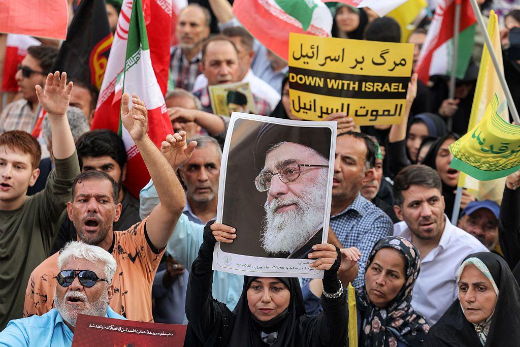 Un manifestante sostiene una imagen del líder supremo de Irán, el ayatolá Alí Jamenei, reunido con otros durante una manifestación en solidaridad con el gobierno contra los ataques de Israel a Irán.