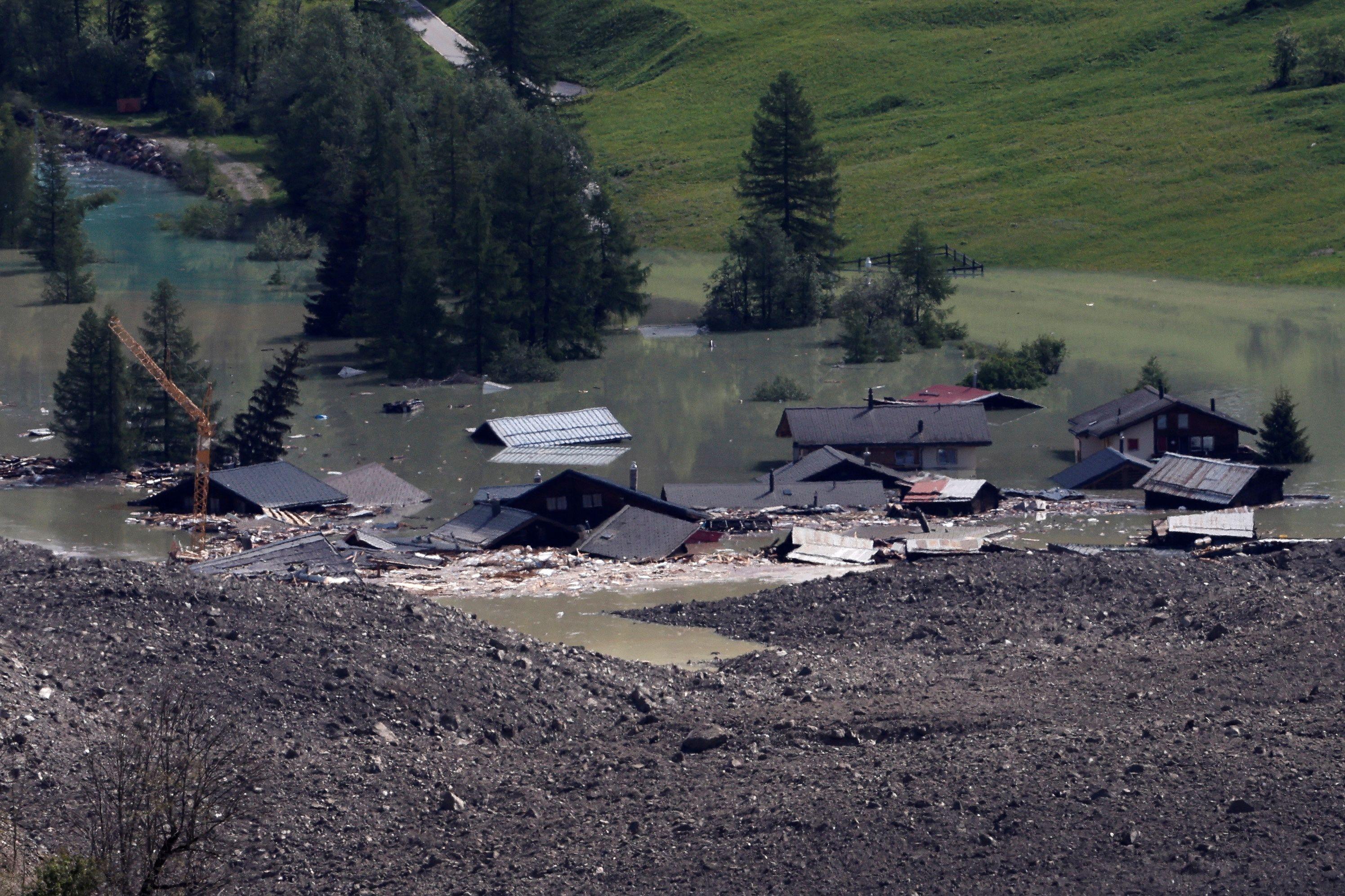 Vista de casas destruidas y tapadas por agua el 29 de mayo de 2025, después de que un deslizamiento masivo de rocas y hielo cubriera la mayor parte del pueblo de Blatten, Suiza.