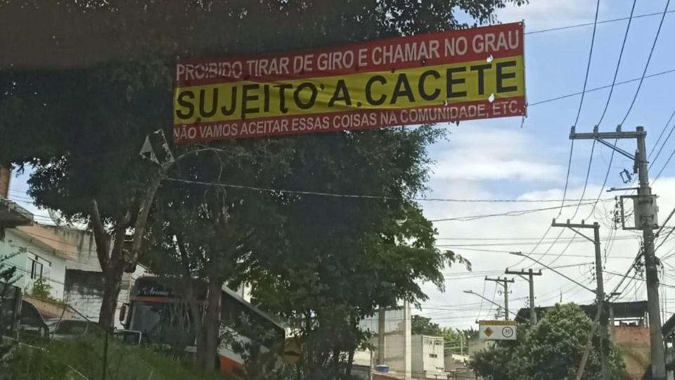 Cartaz com aviso 'Proibido tirar de giro e chamar no grau. Sujeito a cacete. Não vamos aceitar essas coisas na comunidade, etc.'