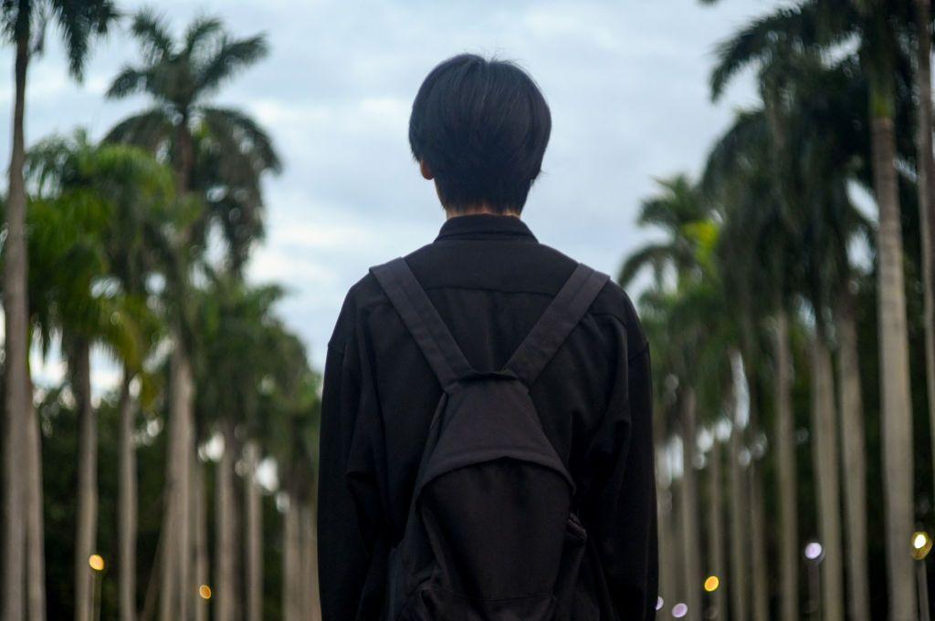 一名學生站在台大椰林大道。