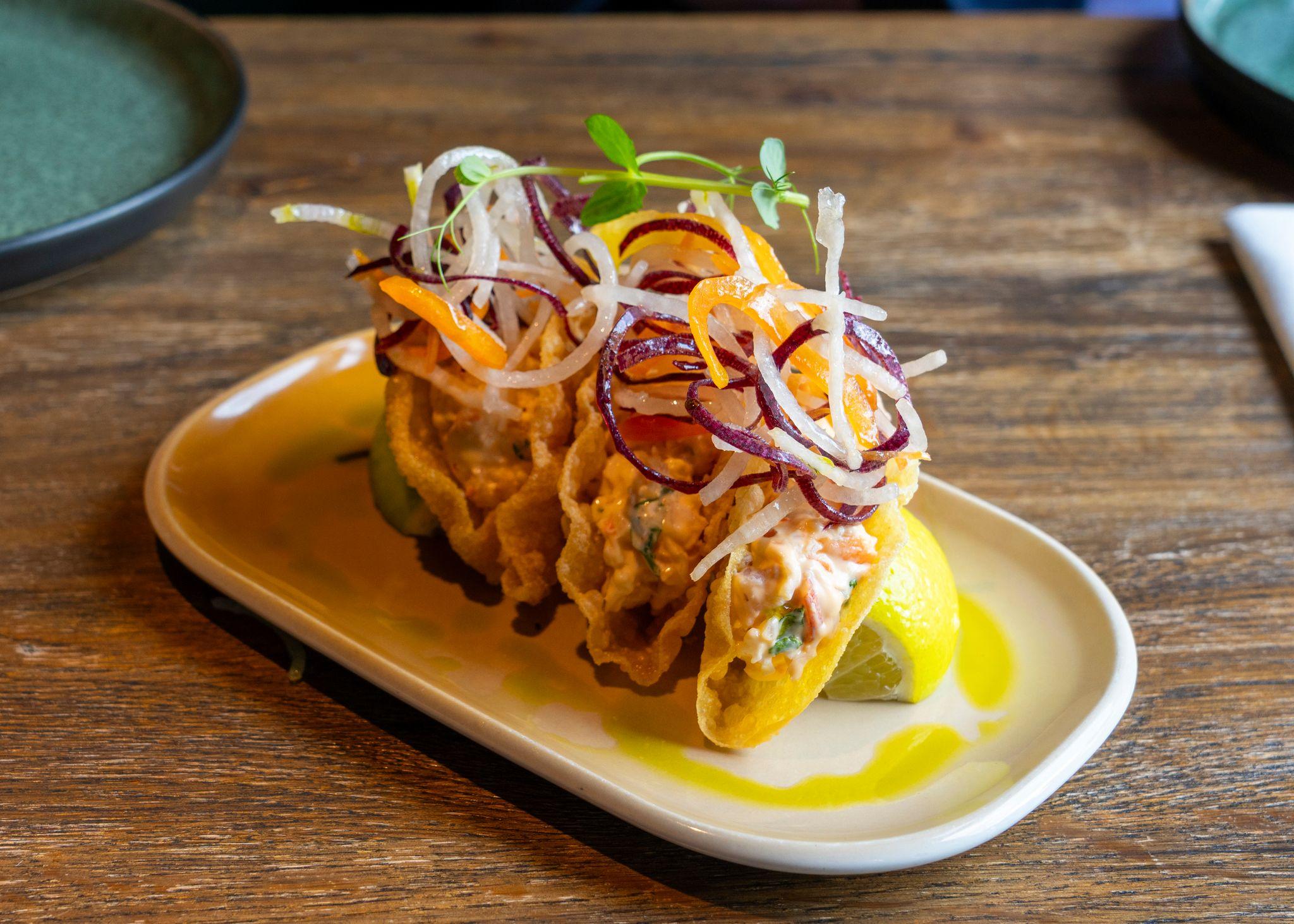 Unos tacos de pescado en un plato blanco