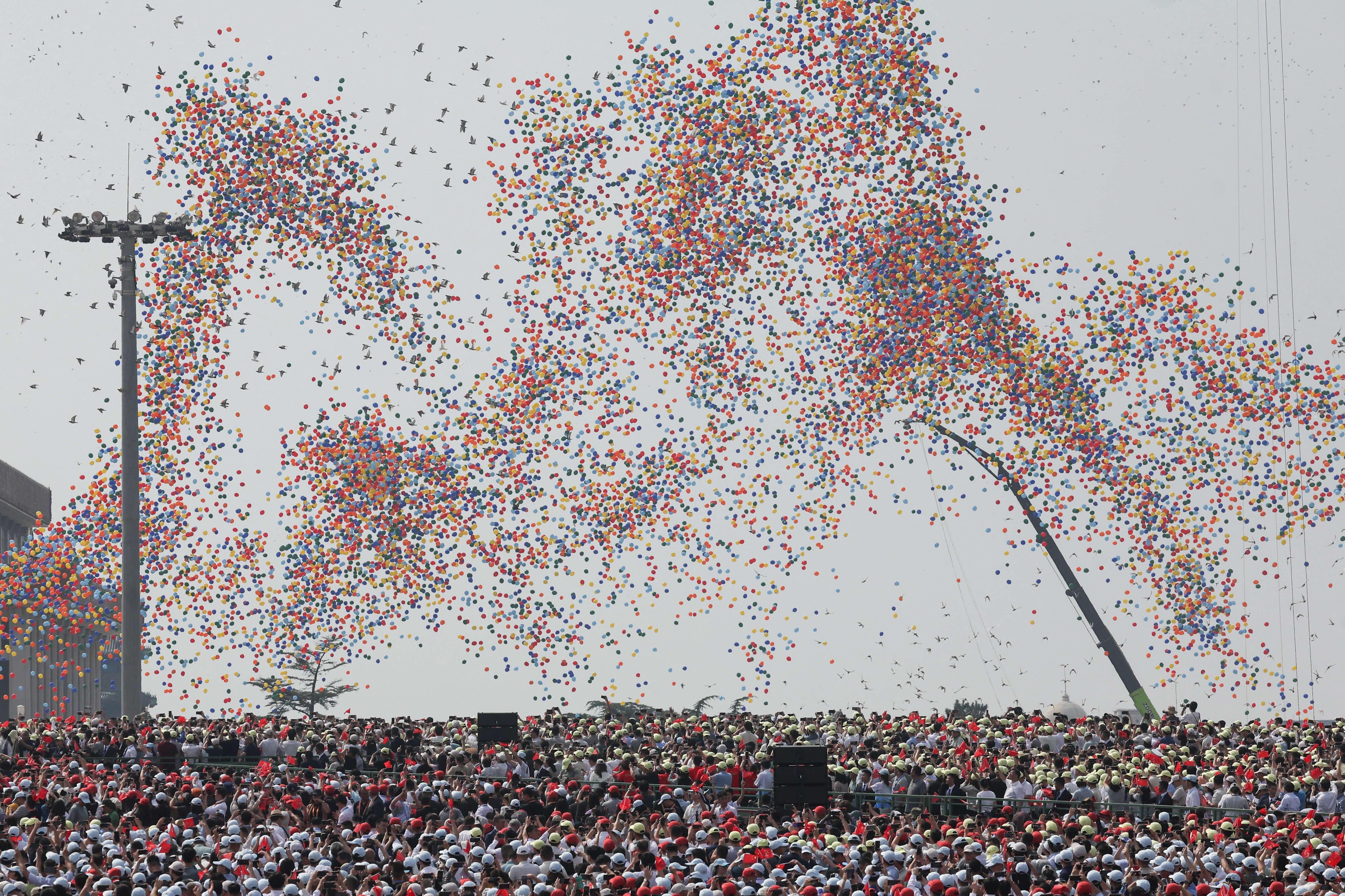 Se liberan globos durante un desfile militar.