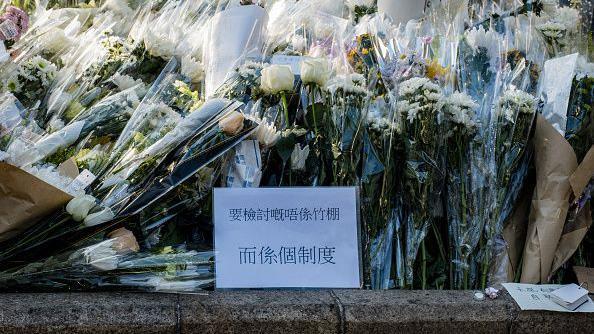 2025年11月29日，巿民在宏福苑附近公園擺放鮮花悼念罹難者，一張紙張上寫著：「要檢討的不是竹棚，而是制度」。