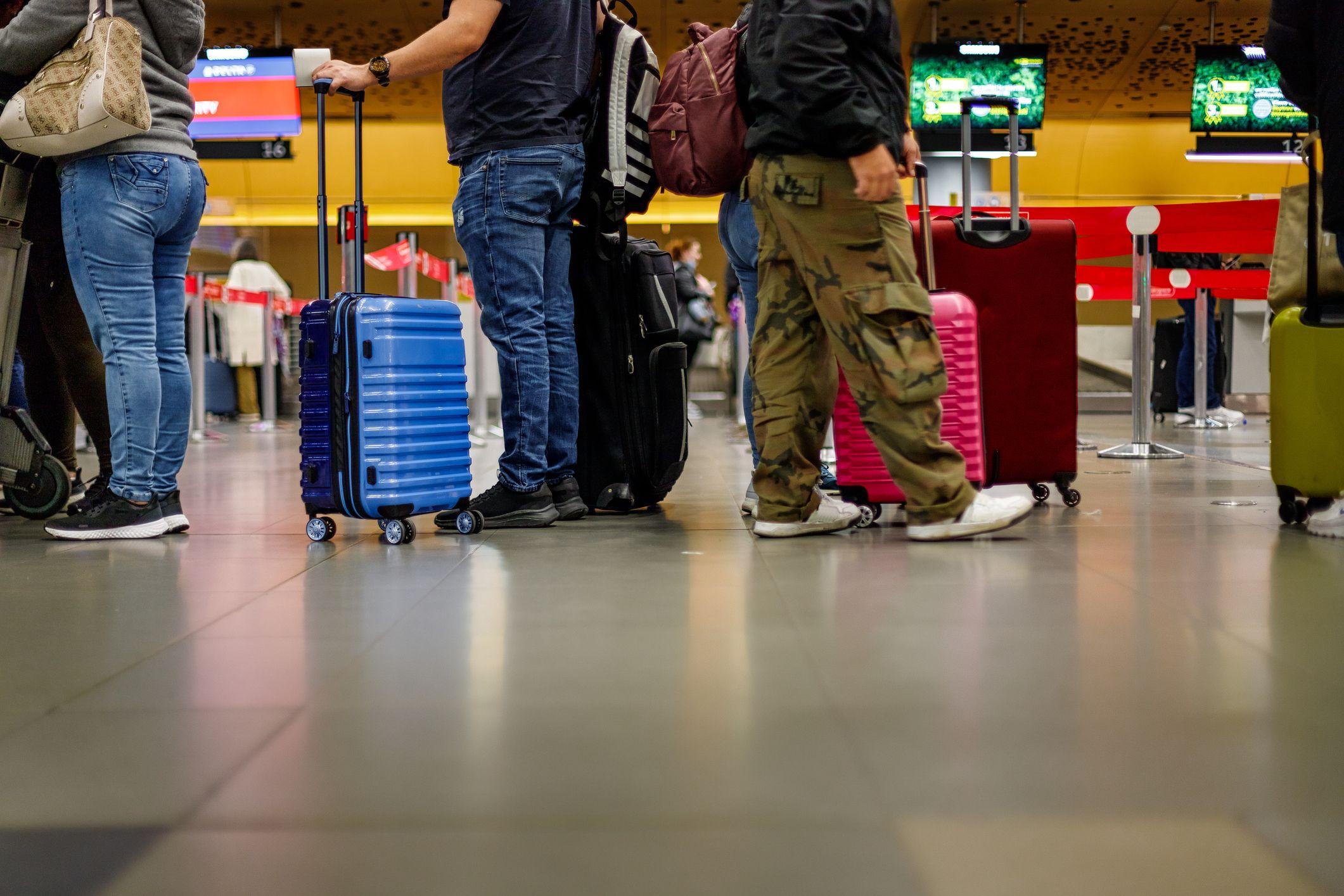 Pasajeros en fila con sus maletas en el aeropuerto de Bogotá.