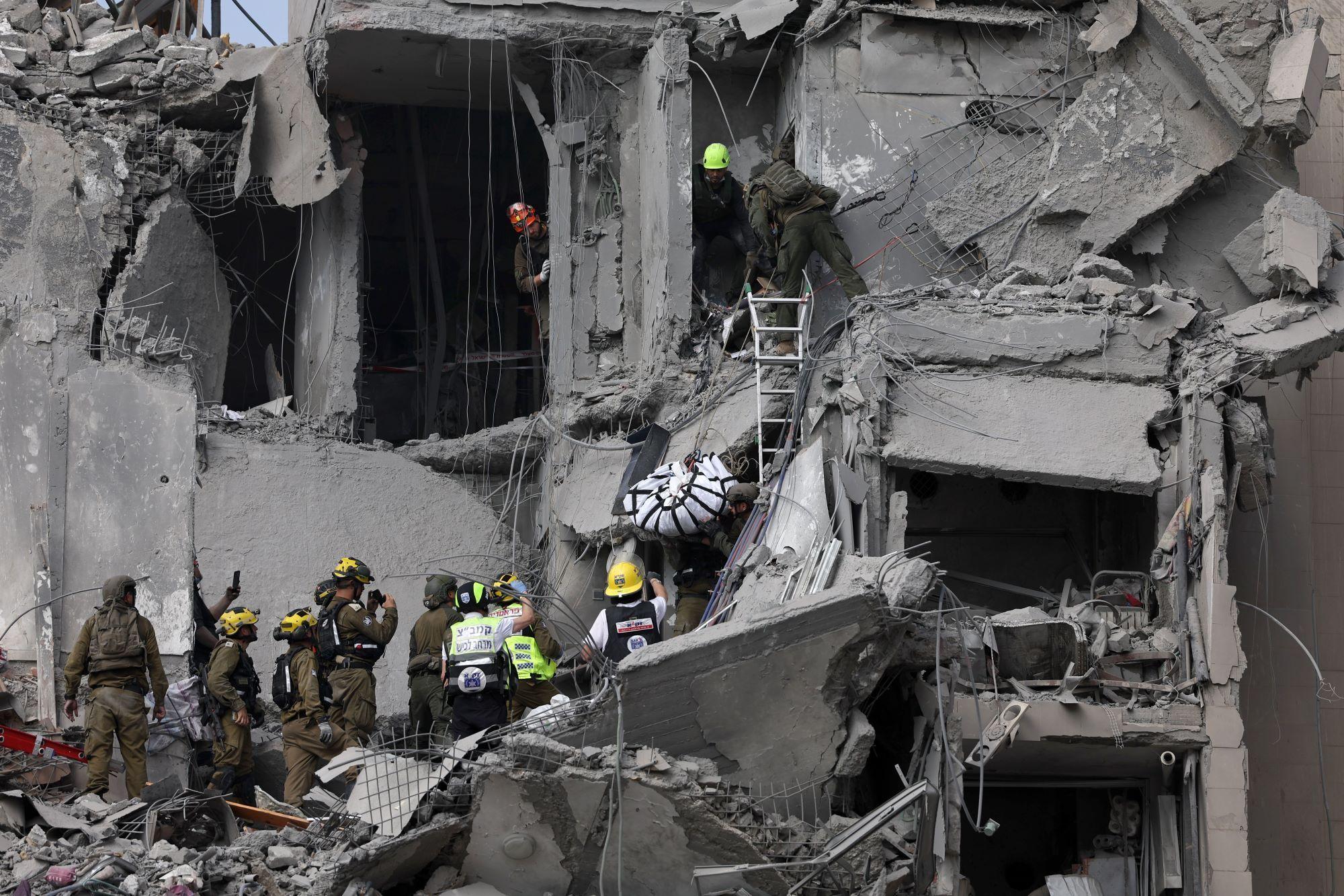 Prédio destruído em Israel, com equipes de resgate
