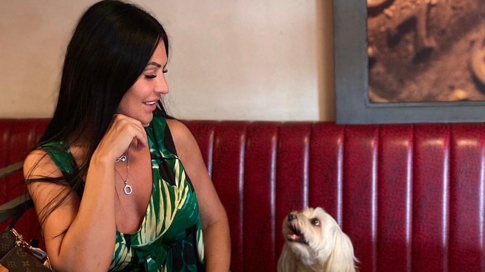 Pas sedi pored crnokose žene u restoranu