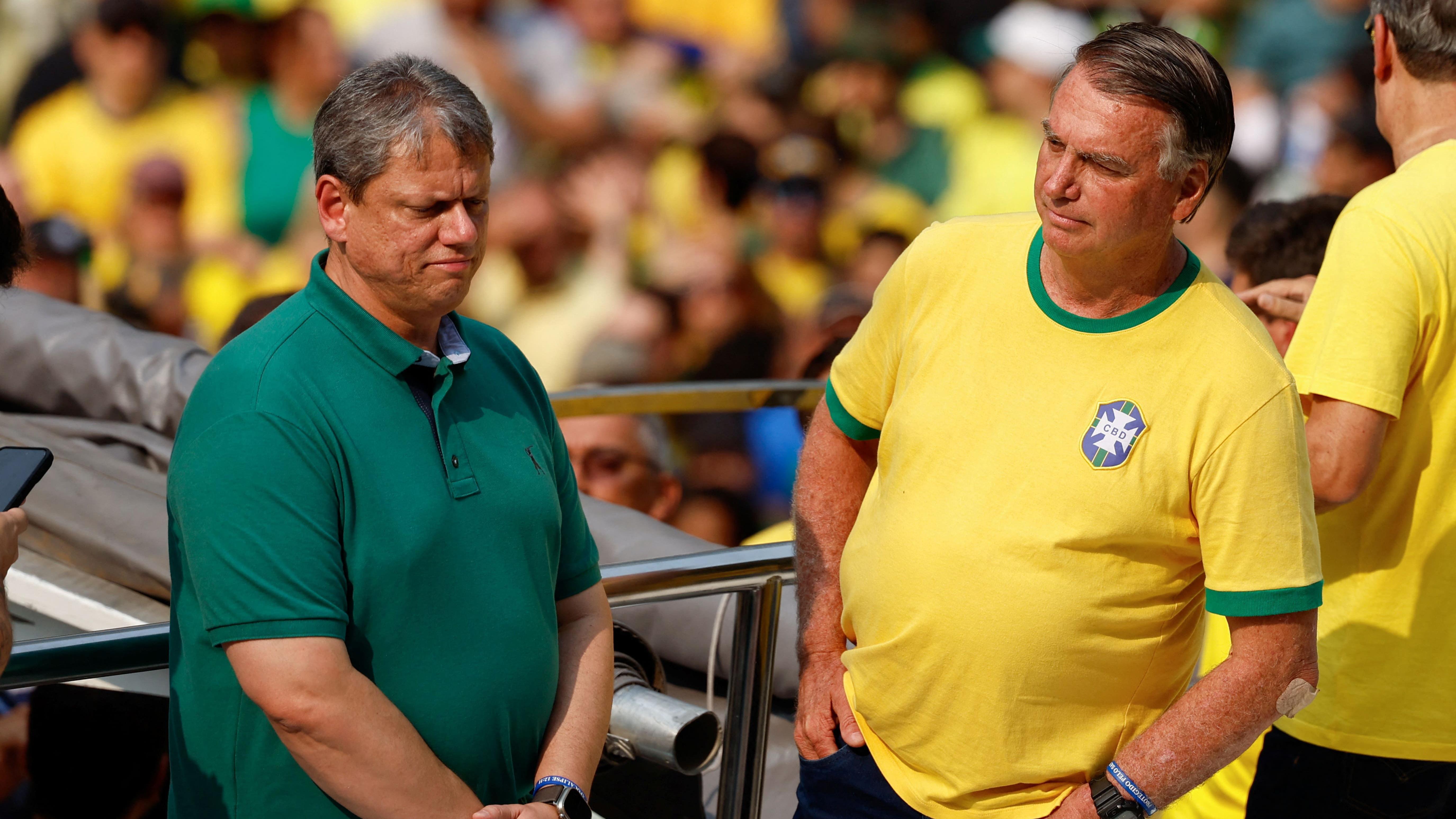 Tarcísio com aspecto cabisbaixo ao lado de Bolsonaro, em um caminhão de som 