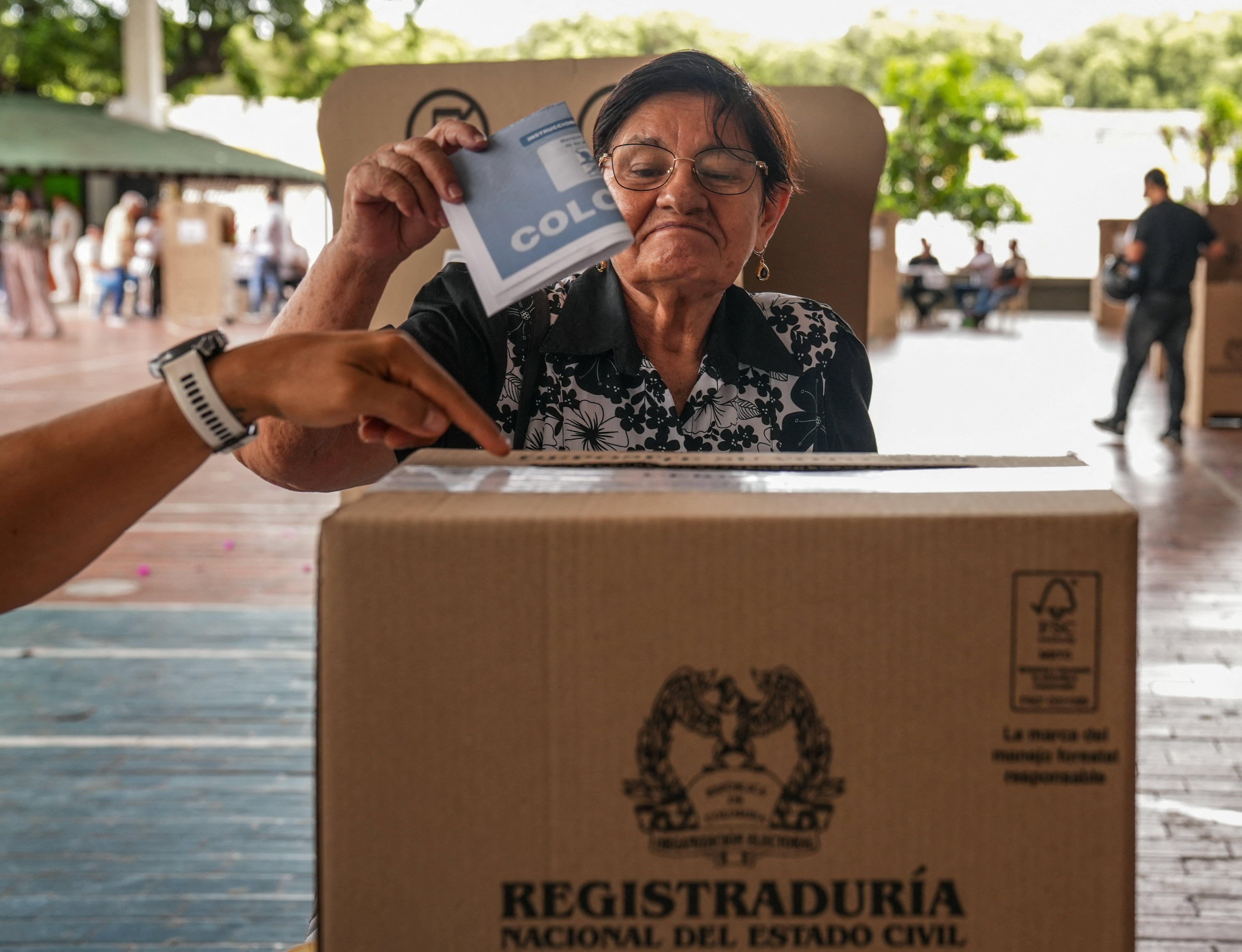 Una mujer colombiana depositando su voto en una urna