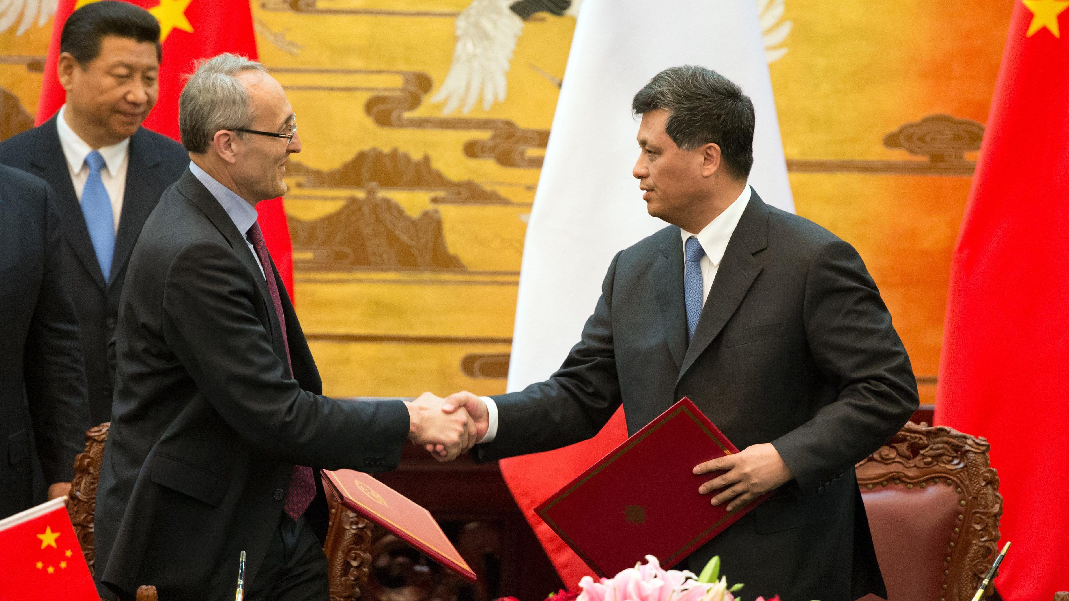 This photo taken on April 25, 2013 shows French Atomic Energy Commission chairman Bernard Bigot (2nd L) shaking hands with Chinese Atomic Energy Authority (CAEA) Ma Xingrui (R) during a signing ceremony overseen by French President Francois Hollande (not pictured) and Chinese President Xi Jinping (back L) at the Great Hall of the People in Beijing