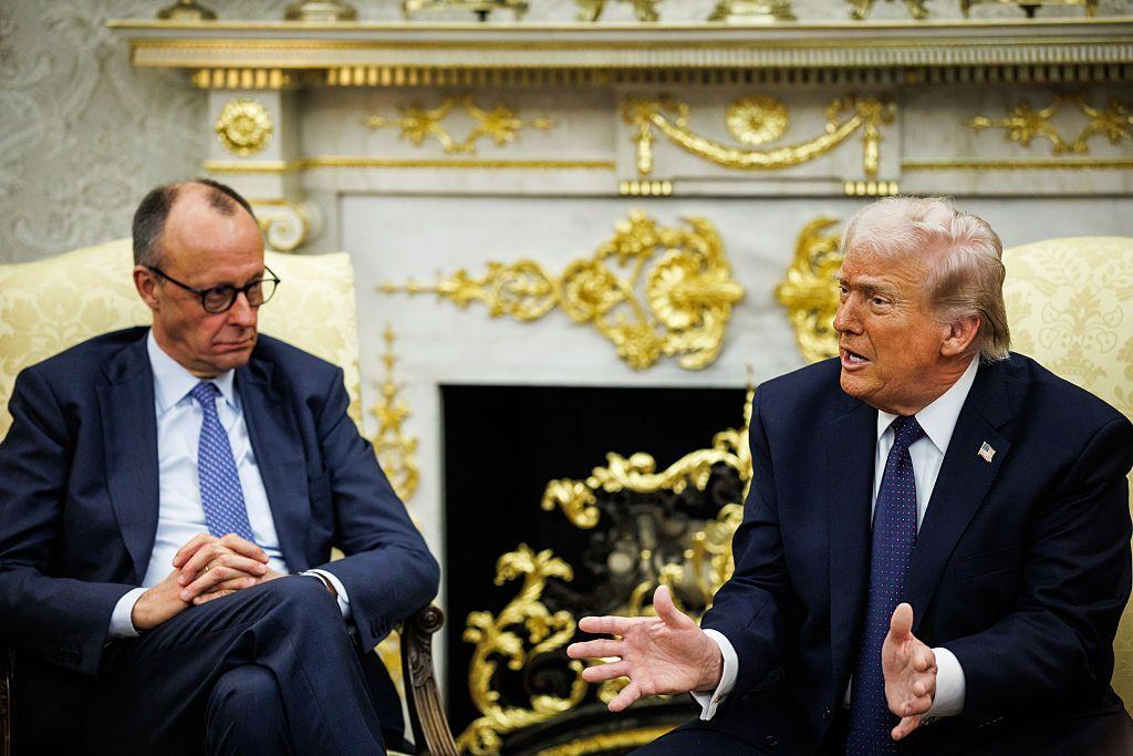 Friedrich Merz, canciller de Alemania, a la izquierda, y el presidente de los Estados Unidos, Donald Trump, durante una reunión en la Oficina Oval. Ambos están sentados, vestidos con traje de chaqueta y corbata. El fondo es una decorazión blanca y llena de detalles dorados. 