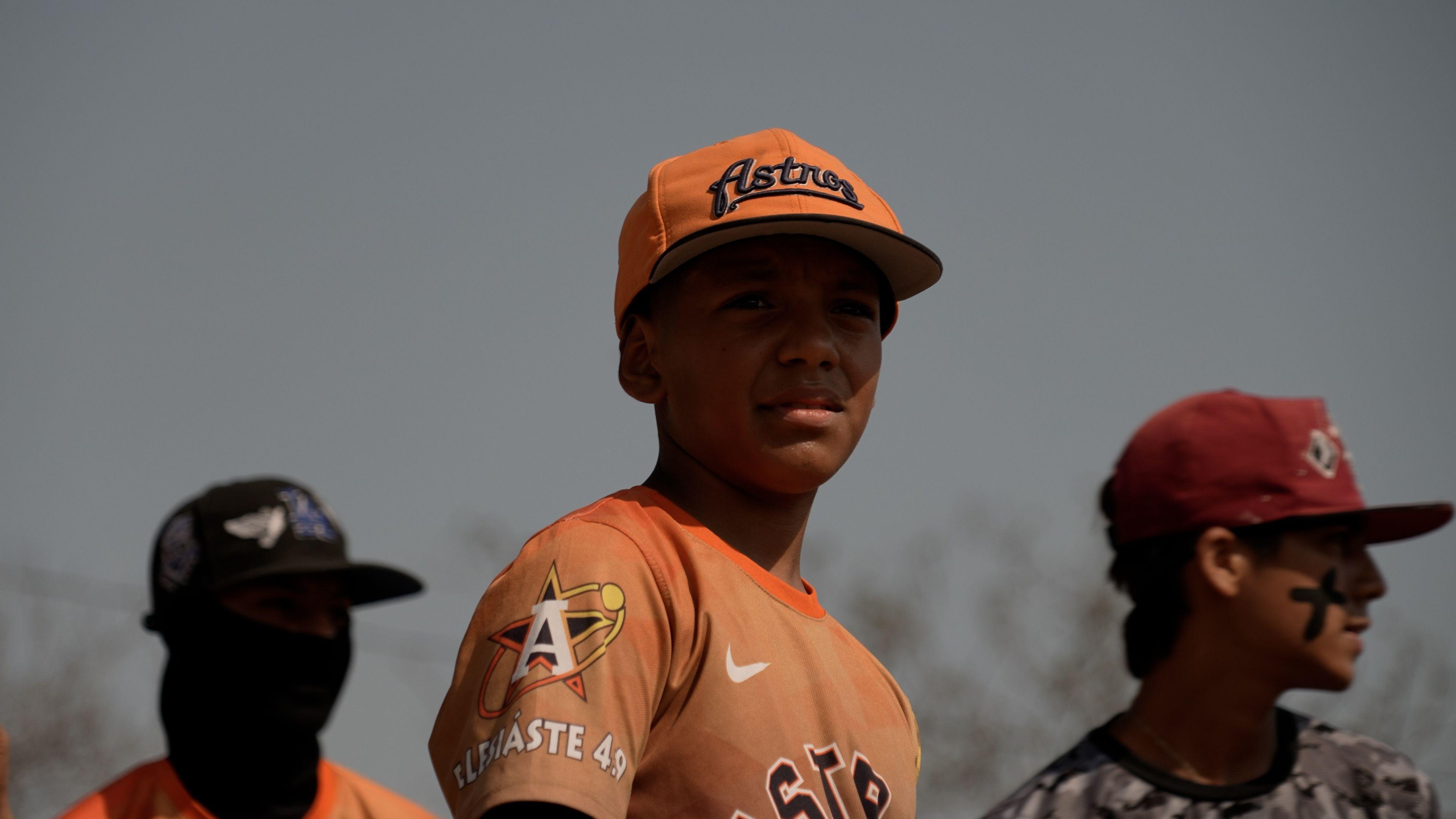 Niños jugando al béisbol.