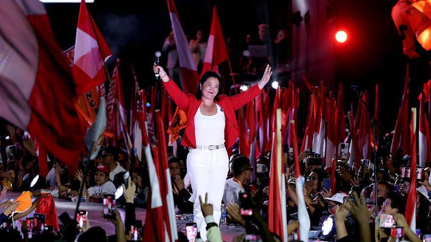 Keiko Fujimori saluda a simpatizantes en un acto de Perú con varias banderas del país en junio de 2026. 