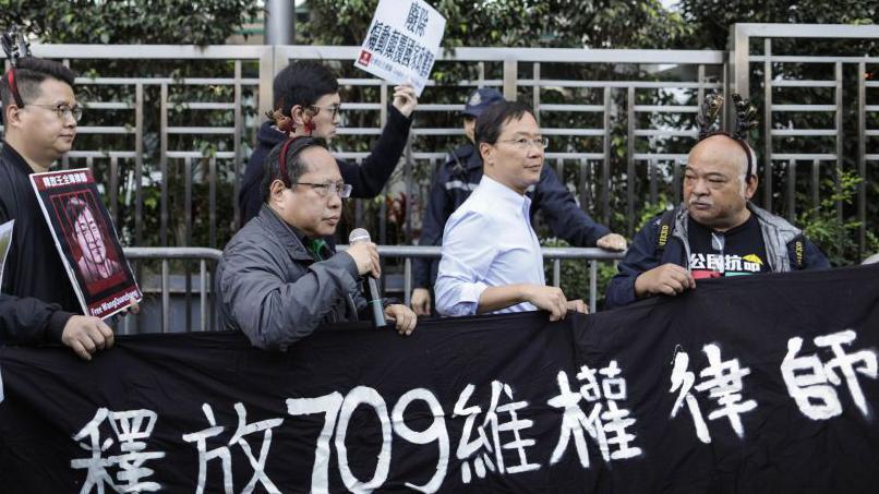 2018年12月26日，一群香港的示威者在中聯辦外拿起寫有「釋放709維權律師」的橫額。