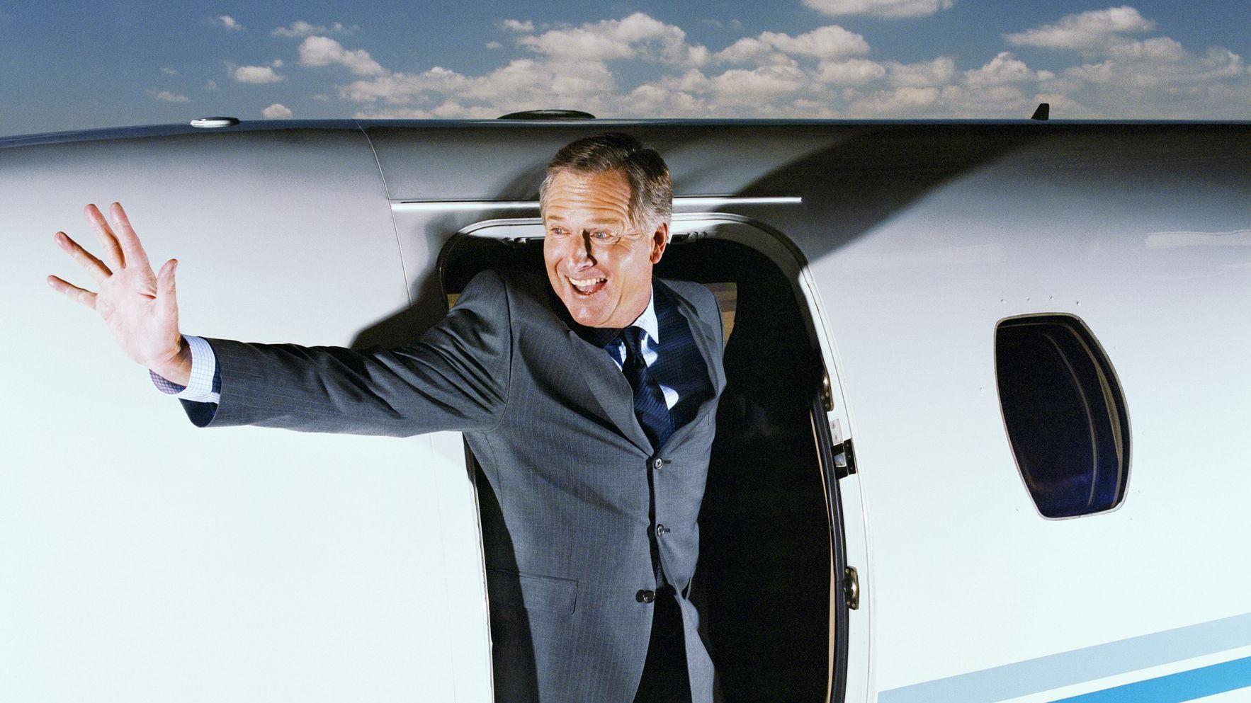 Executivo acenando ao embarcar em um jatinho privado